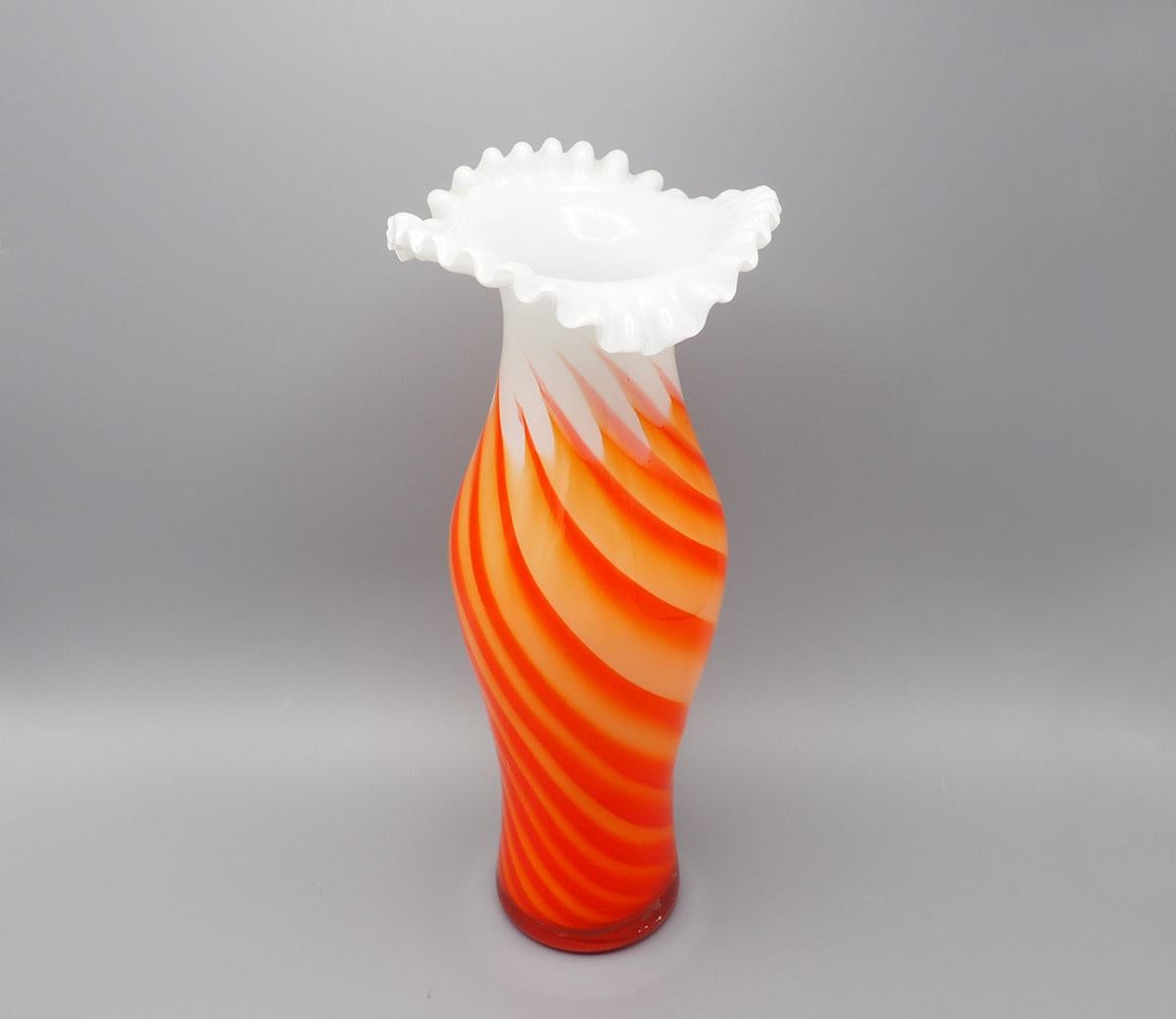 Magnifique vase en verre vintage des années 60/70 fait à la main par Opaline Florence Italie.

Le vase est composé de verre blanc et de verre orange torsadé.

Le haut s'évase avec un bord ondulé.

Attire tous les regards dans votre intérieur,