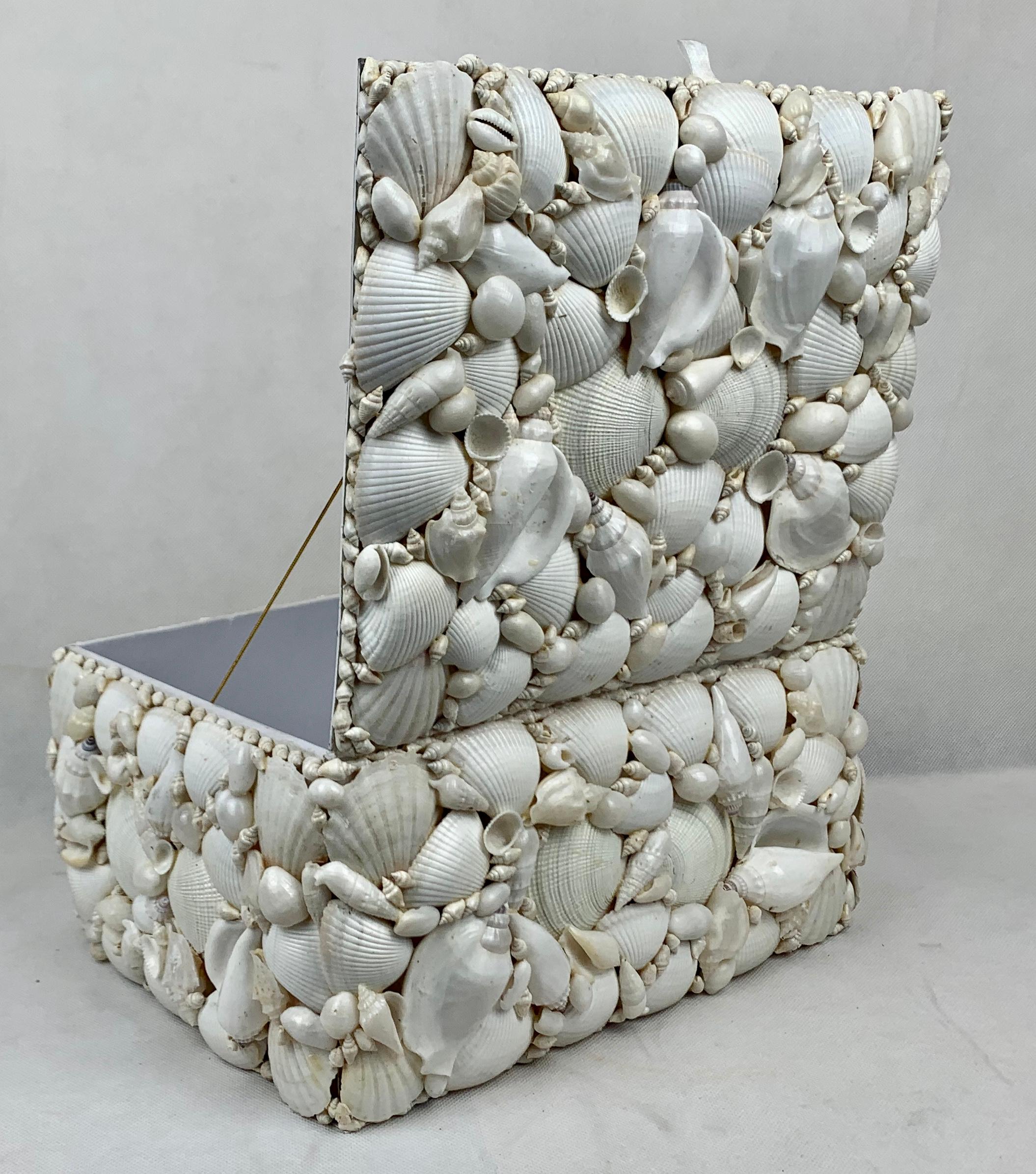 Large box encrusted with natural white sea shells. The box is hinged and lined in white. The shells are arranged in an attractive pattern with tiny shells used to create a border.
This is one of the larger boxes of its type that I have come