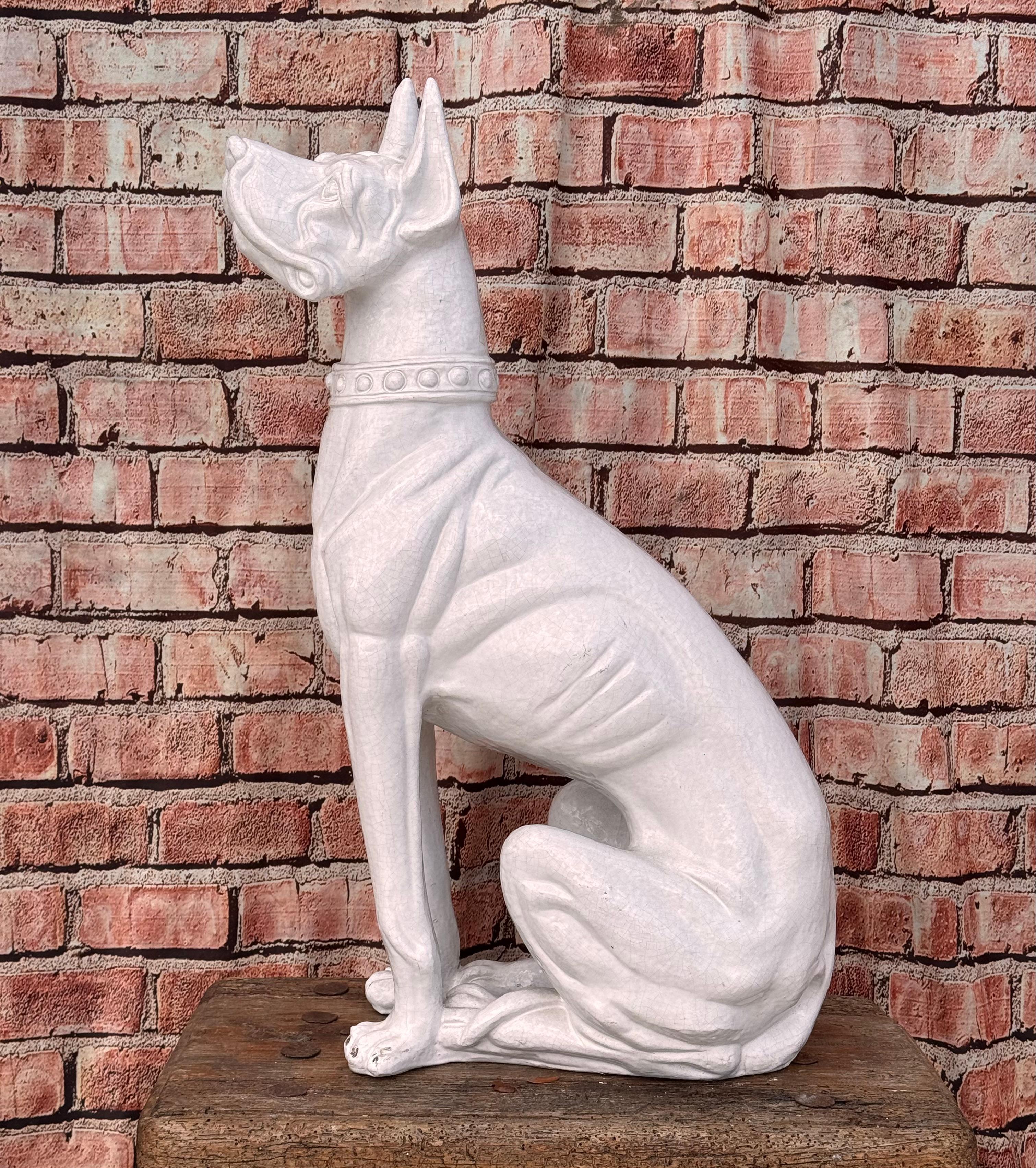 Statue de dogue en terre cuite italienne du milieu du siècle. Le Grand Danois, connu pour son apparence imposante mais gracieuse, est représenté en position assise, ce qui permet de saisir sa taille majestueuse et ses traits élancés. La couleur