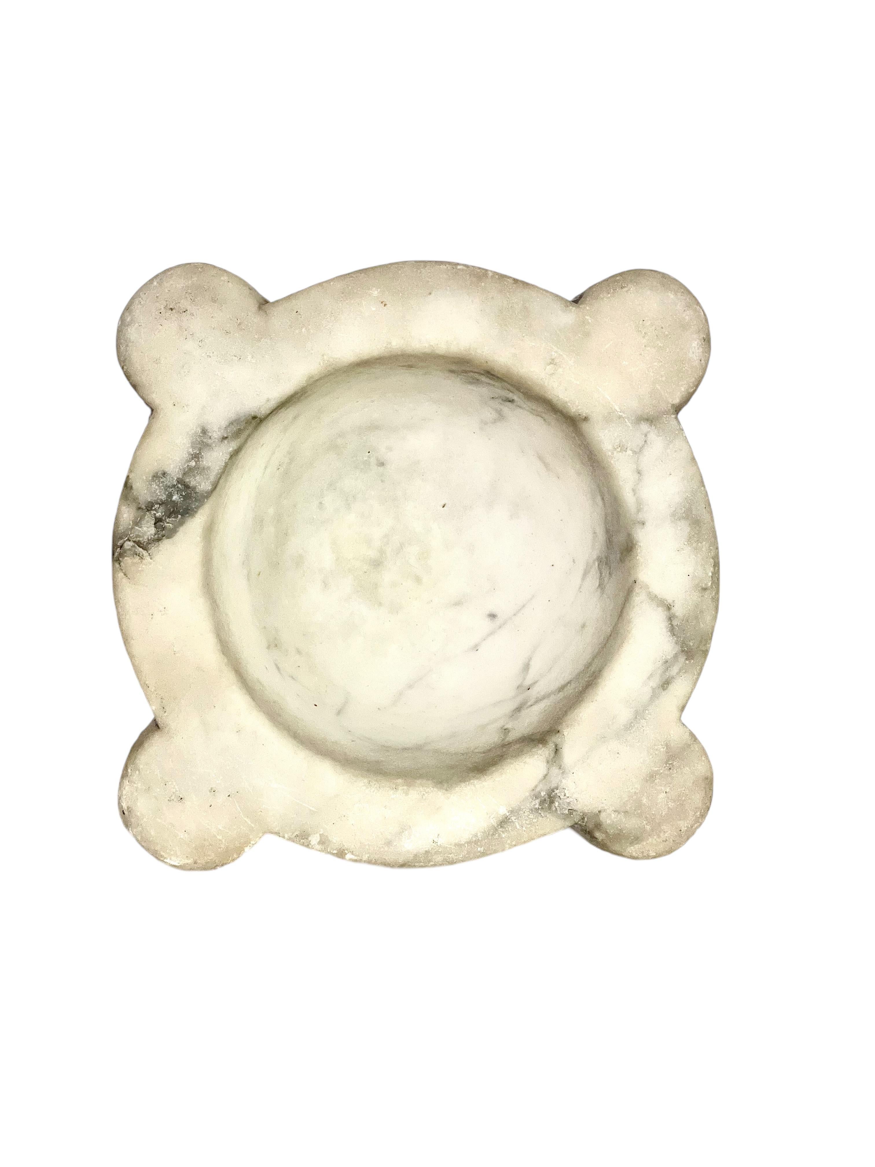 Un mortaio del XVIII secolo realizzato in marmo di Carrara scolpito a mano e con bellissime venature. Realizzato nello stile tradizionale, con quattro angoli sagomati e una ciotola profonda, un tempo veniva utilizzato come strumento da farmacia o da
