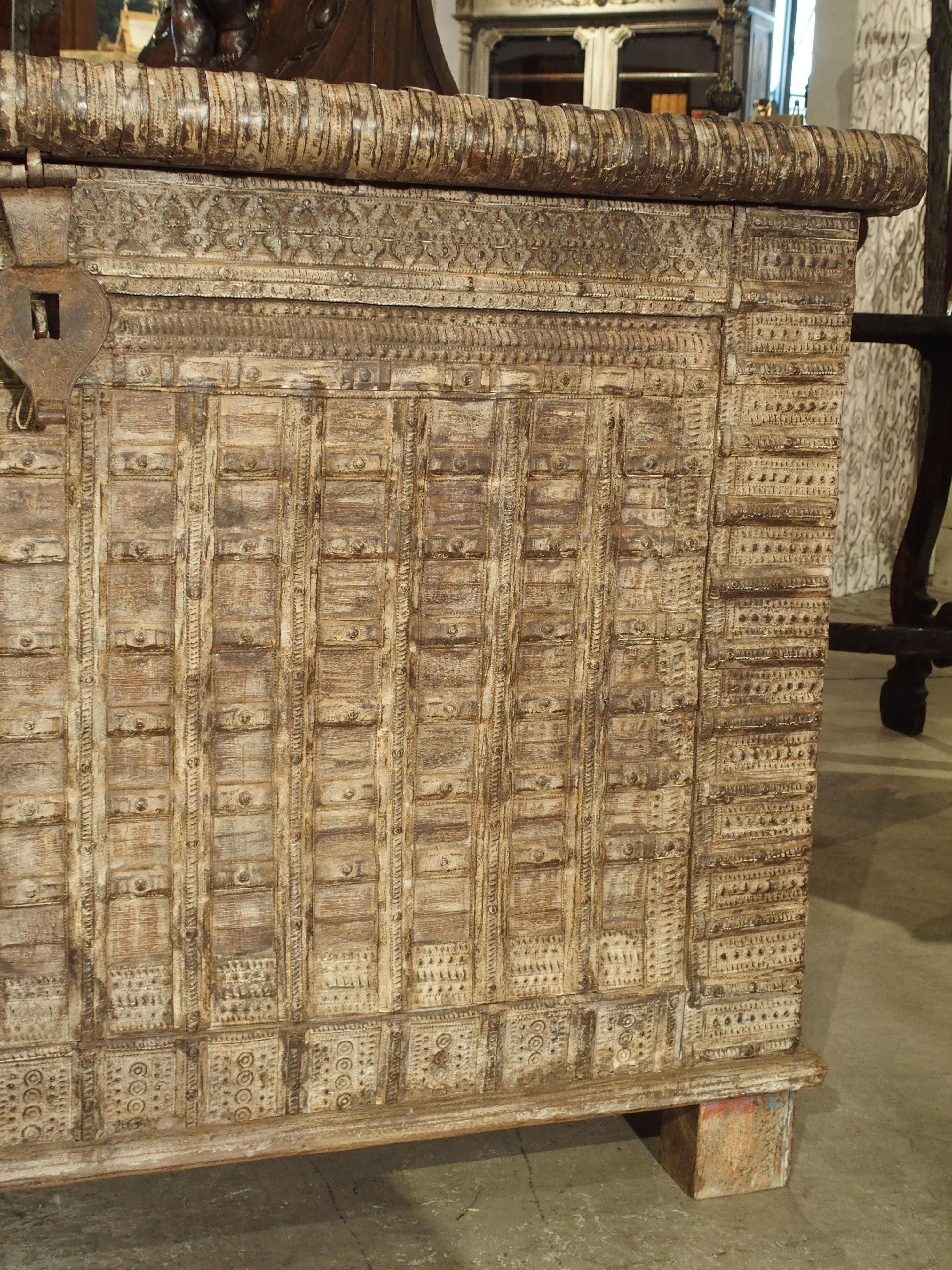 This large iron and whitewashed wooden trunk from India has been made with antique elements. It is the perfect height for use as a serving piece, console or storage trunk. Whitewashing the trunk gives it an overall uniformity, yet shows there is