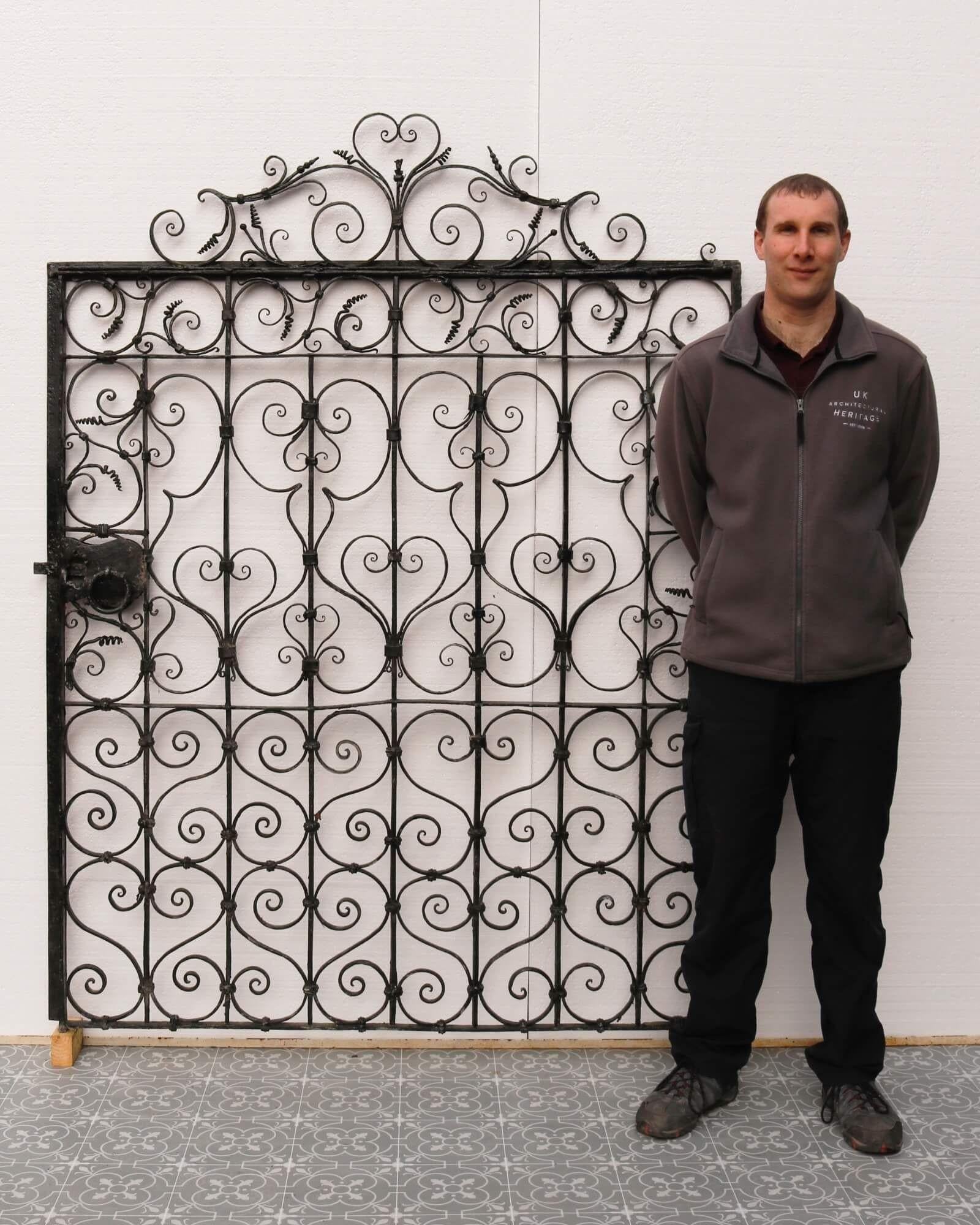This large antique wrought iron pedestrian gate is a superb addition to any garden with its handsome scrollwork and impressive scale. Circa 1850, this wide garden side gate is over 170 years old and has stood the test of time, the elaborate
