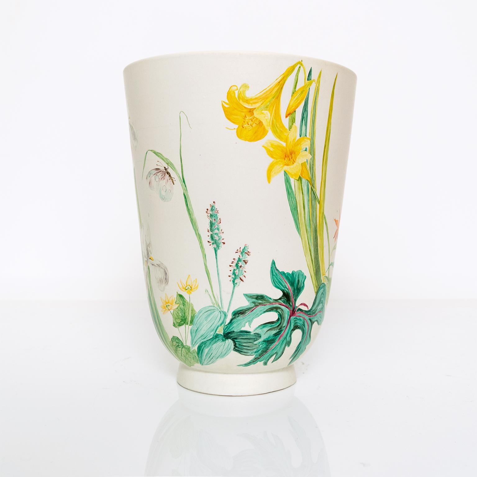 A large hand decorated ceramic vase, form designed by Wilhelm Kage for Gustavsberg. The vase depicts a close up view of a garden with various flowers and a mouse. Very good condition with some glaze lost in the internal bottom. 

Height: 12”