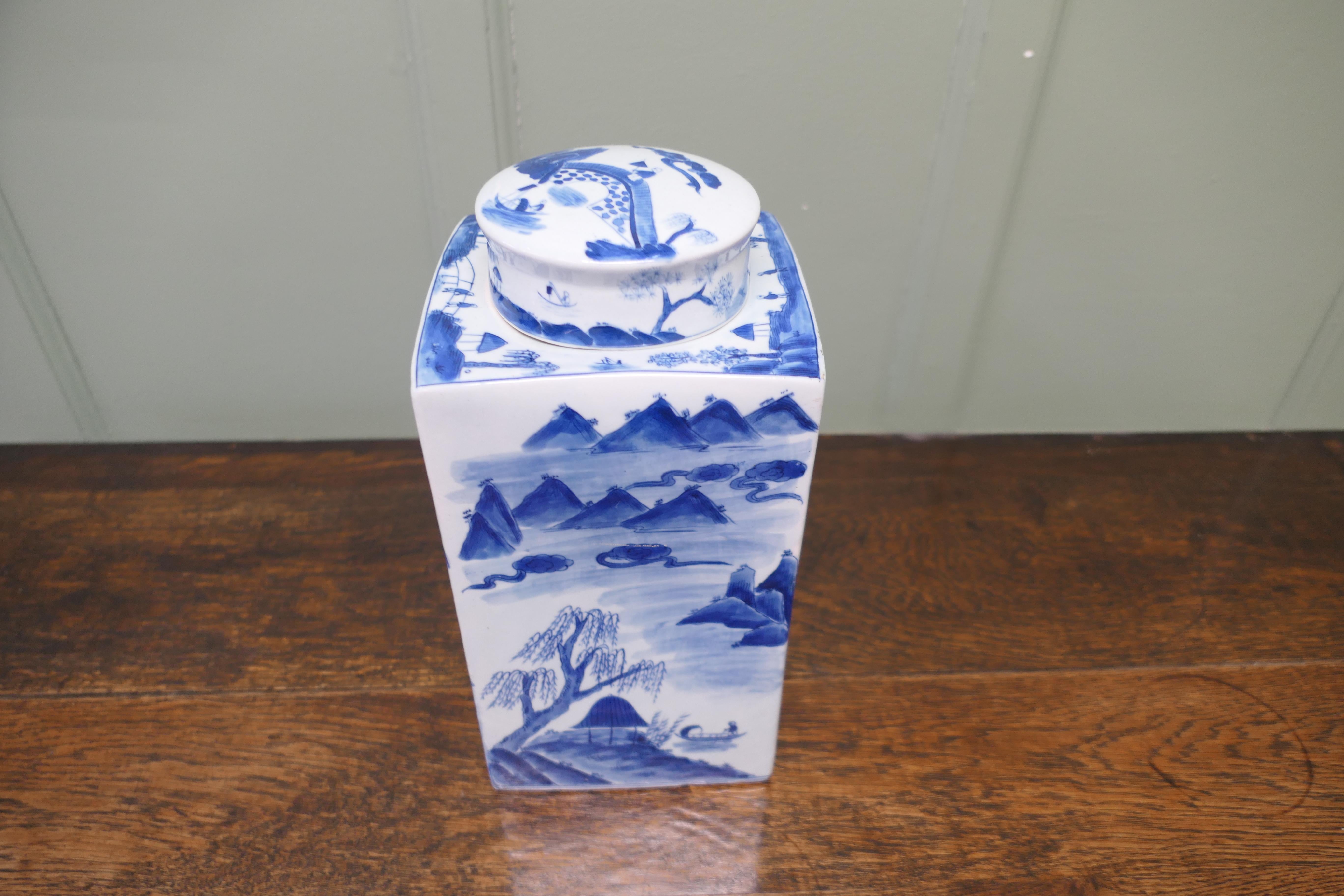 
Large Willow Pattern Storage Canister, Ginger Jar
This beautiful looking large piece is unusually tall and square it is painted in an Old Willow design this runs all the way around telling the old story with bridges and pagodas, it is 14” tall and
