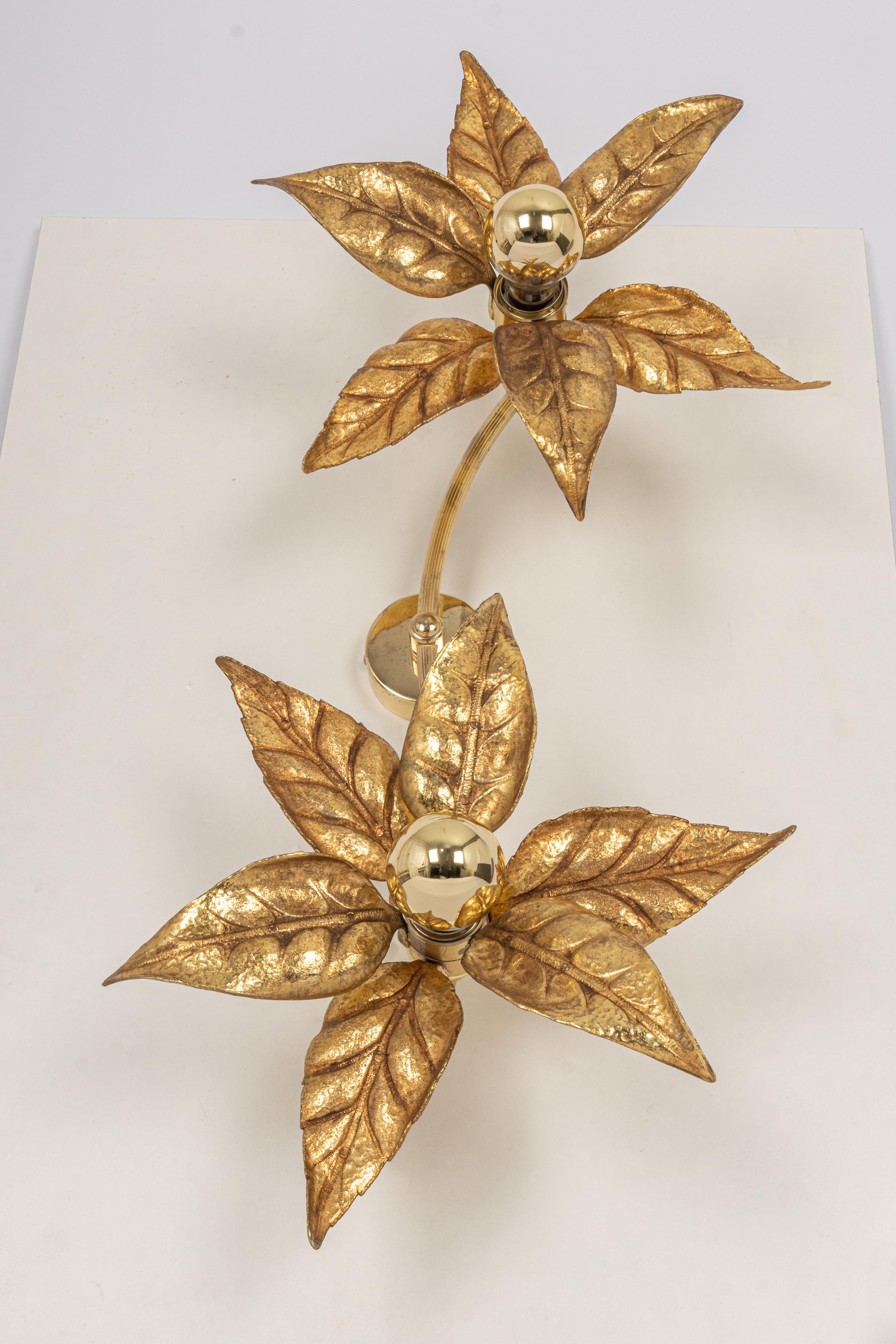 Large brass flowers wall sculptures in the style of designer Willy Daro manufactured by 'Massive Lighting', circa 1970s, Belgium. This decorative and beautiful large sculptural light consists of a pair of brass-plated flowers on a bar and circular