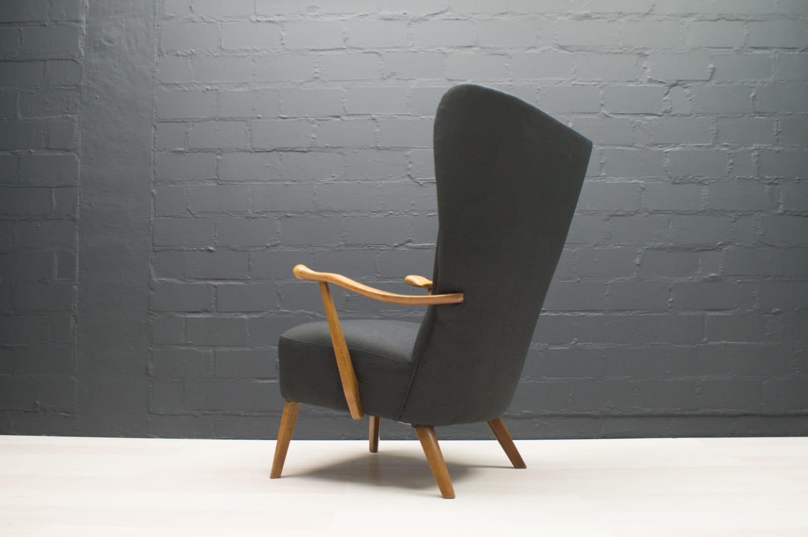 Italian large wingback chair in anthracite upholstery.

This Classic Italian modern wing chair has an unusually high backrest and graceful wings. The elegant armrests are slightly curved outwards, are ergonomically shaped and the seat has gently