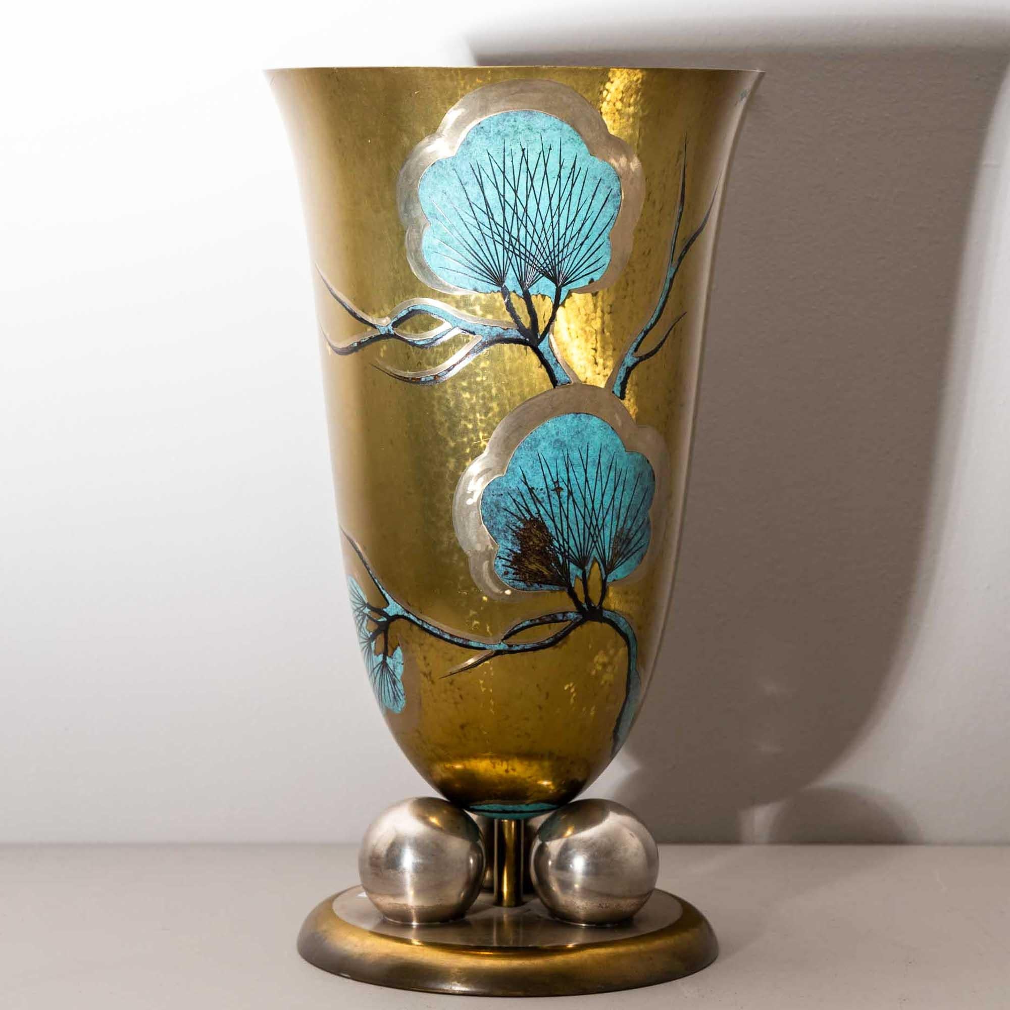 Large WMF vase dating back to the 1920s or 30s. The tulip-shaped vase is elegantly elevated on a round base supported by three spheres. Its gold-ground wall is adorned with turquoise stylized pine branches in an Asian-inspired design, reflecting the