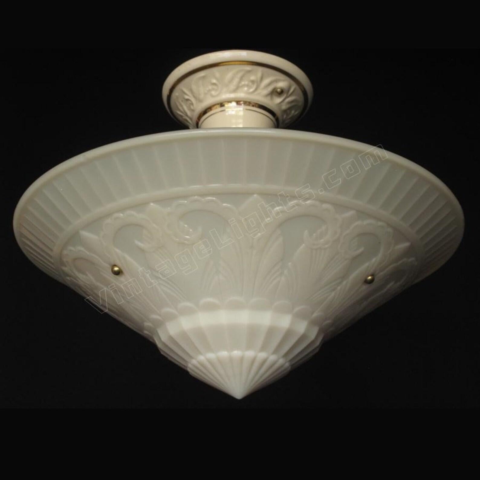 L'un de nos abat-jour préférés est cet abat-jour suspendu à motif floral superbement détaillé, inspiré de la décoration. Ce luminaire antique mesure 15 1/2 pouces de large, ce qui en fait un objet fascinant lorsqu'il est allumé. Le verre à crème a