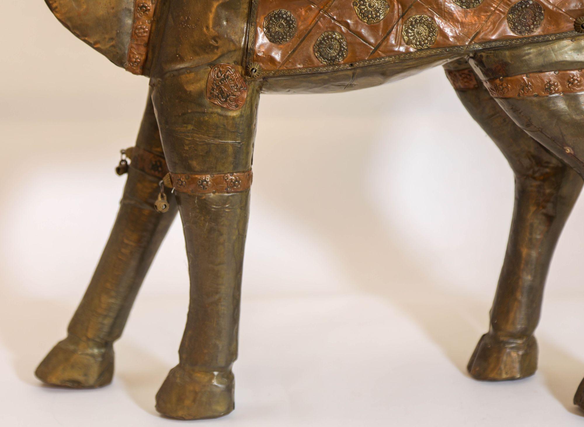 Figura de camello grande y pesada, hecha a mano en madera de época, recubierta de latón y cobre con un aspecto envejecido.
Escultura de camello vintage de los años 50 tallada en madera maciza con cobre y latón.
Tallada a mano en madera y decorada