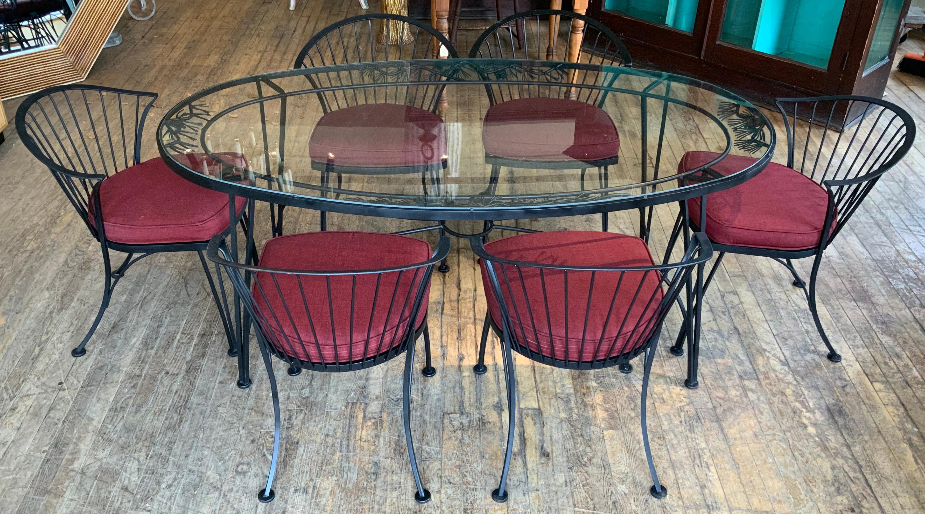 A vintage 1950s wrought iron garden dining set by Woodard. 'Pinecrest' was one of their most charming designs in the 1950s, named for the pine needle & pinecone motif in the skirt of the dining table. this set consists of the largest oval dining
