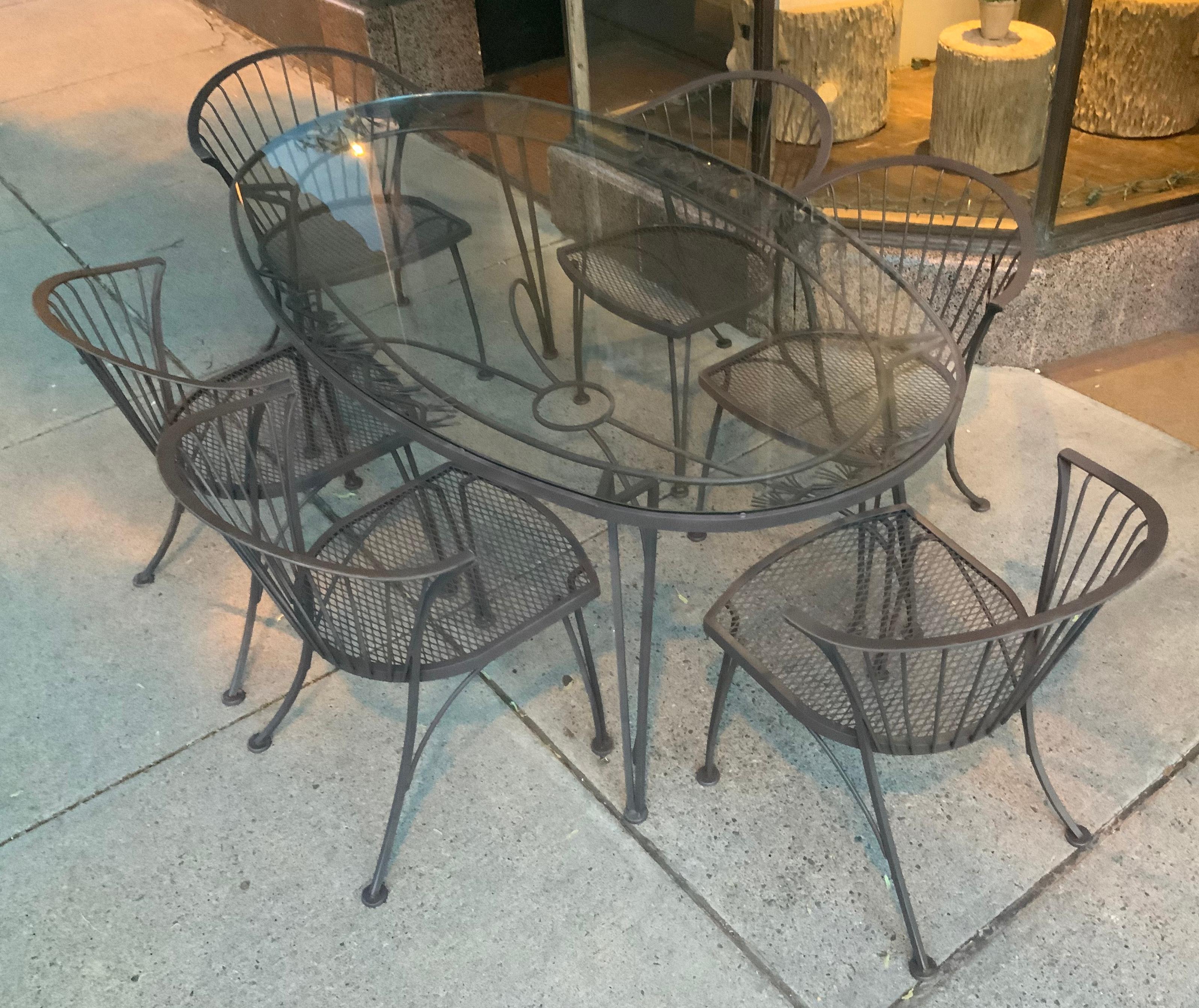 A vintage 1950s wrought iron garden dining set by Woodard. 'Pinecrest' was one of their most charming designs in the 1950s, named for the pine needle & pinecone motif in the skirt of the dining table. this set consists of the largest oval dining