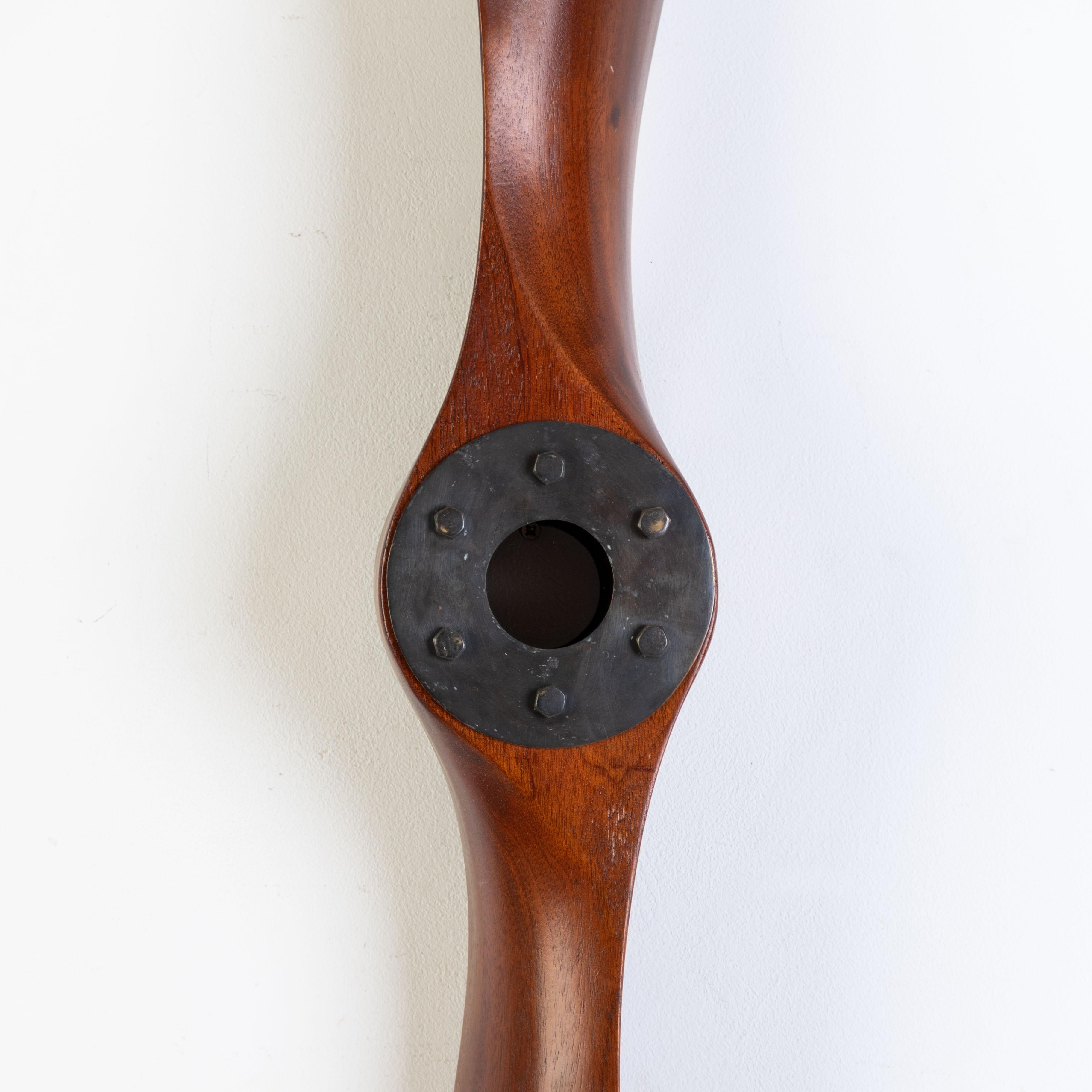 Cette grande hélice d'avion en bois est une pièce frappante et nostalgique, parfaite pour les passionnés d'aviation ou toute personne à la recherche d'un accent audacieux et vintage pour leur espace. Fabriquée en bois massif, cette hélice présente