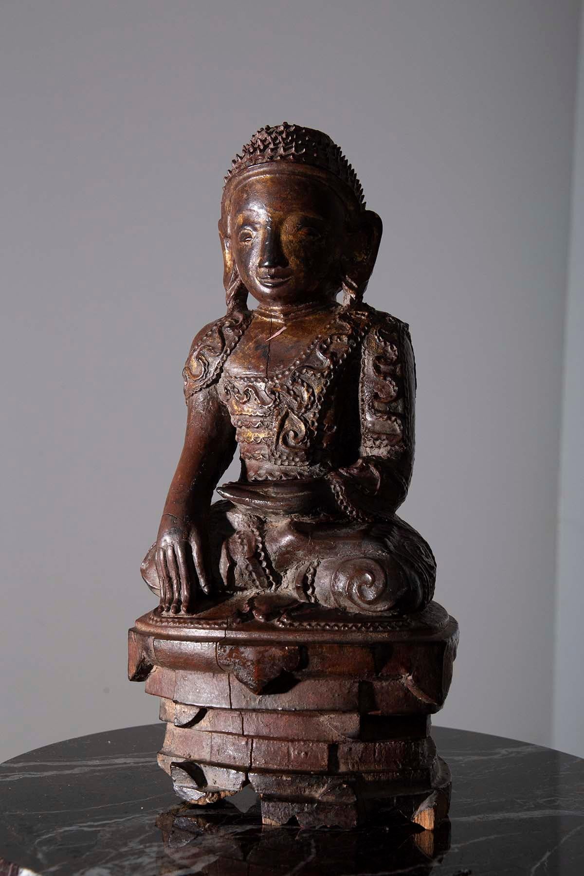 m Herzen Ihres heiligen Raums befindet sich ein zeitloses Meisterwerk - eine prächtige hölzerne Buddha-Skulptur, die die Geheimnisse der Zeitalter flüstert. Diese mit größter Hingabe gefertigte ätherische Kreation soll ihre Wurzeln in den mystischen