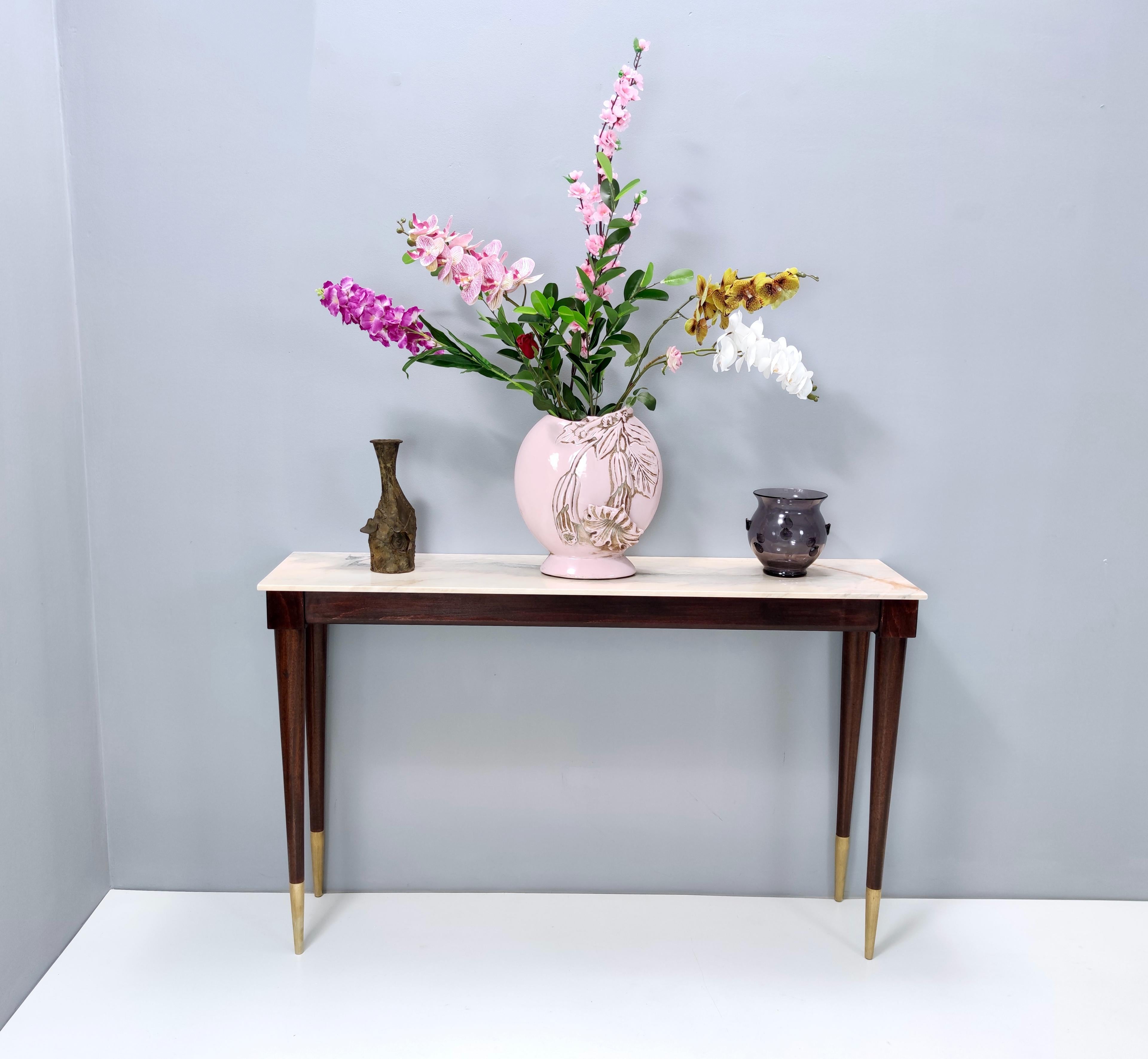 This console table features a mahogany frame, a Portuguese pink marble top and brass feet caps.
It is a vintage piece, therefore it might show slight traces of use, but it can be considered as in excellent original condition since the marble top