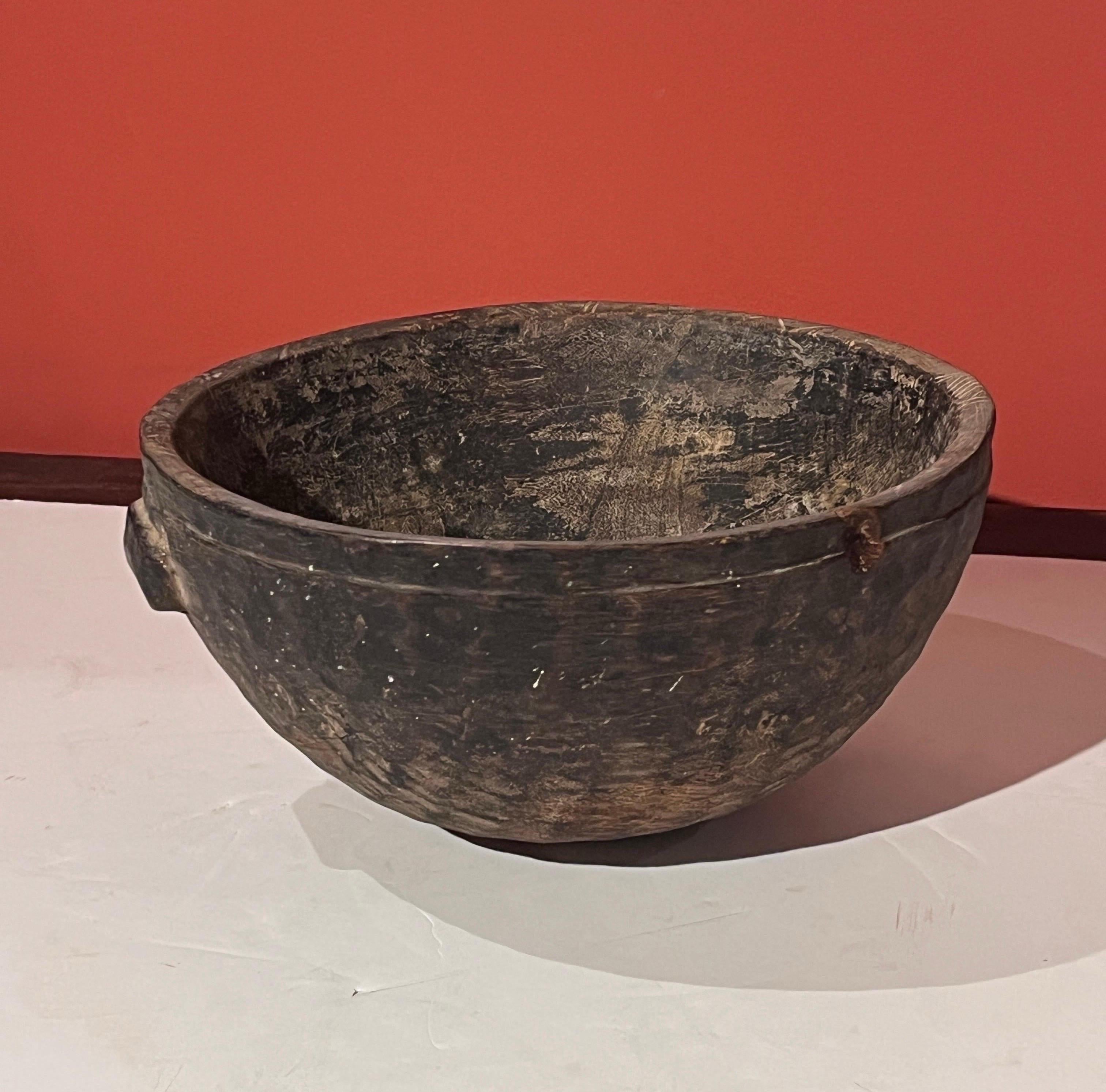 A tall, circular,  hand carved wooden milk bowl from West Africa.  This piece, carved from a single piece of local wood, exhibits a gorgeous patina showing years of use storing and transporting milk.  Made by  the semi nomadic  Tuareg people of