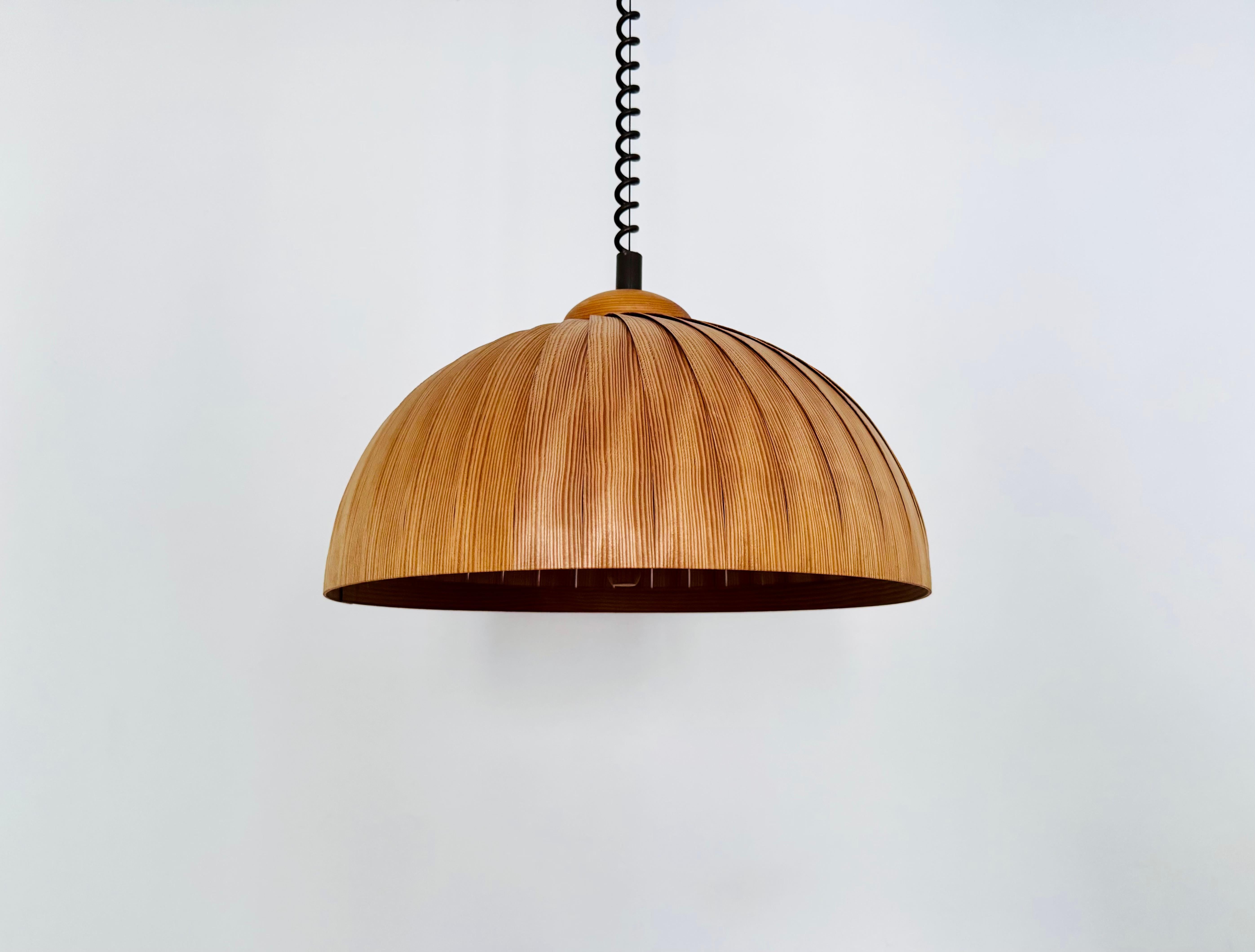Lampada a sospensione in legno di straordinaria bellezza degli anni '60.
Lavorazione amorevole e di alta qualità.
Il design e il materiale creano una luce molto calda e piacevole.
Altezza regolabile in modo continuo grazie alla funzione di