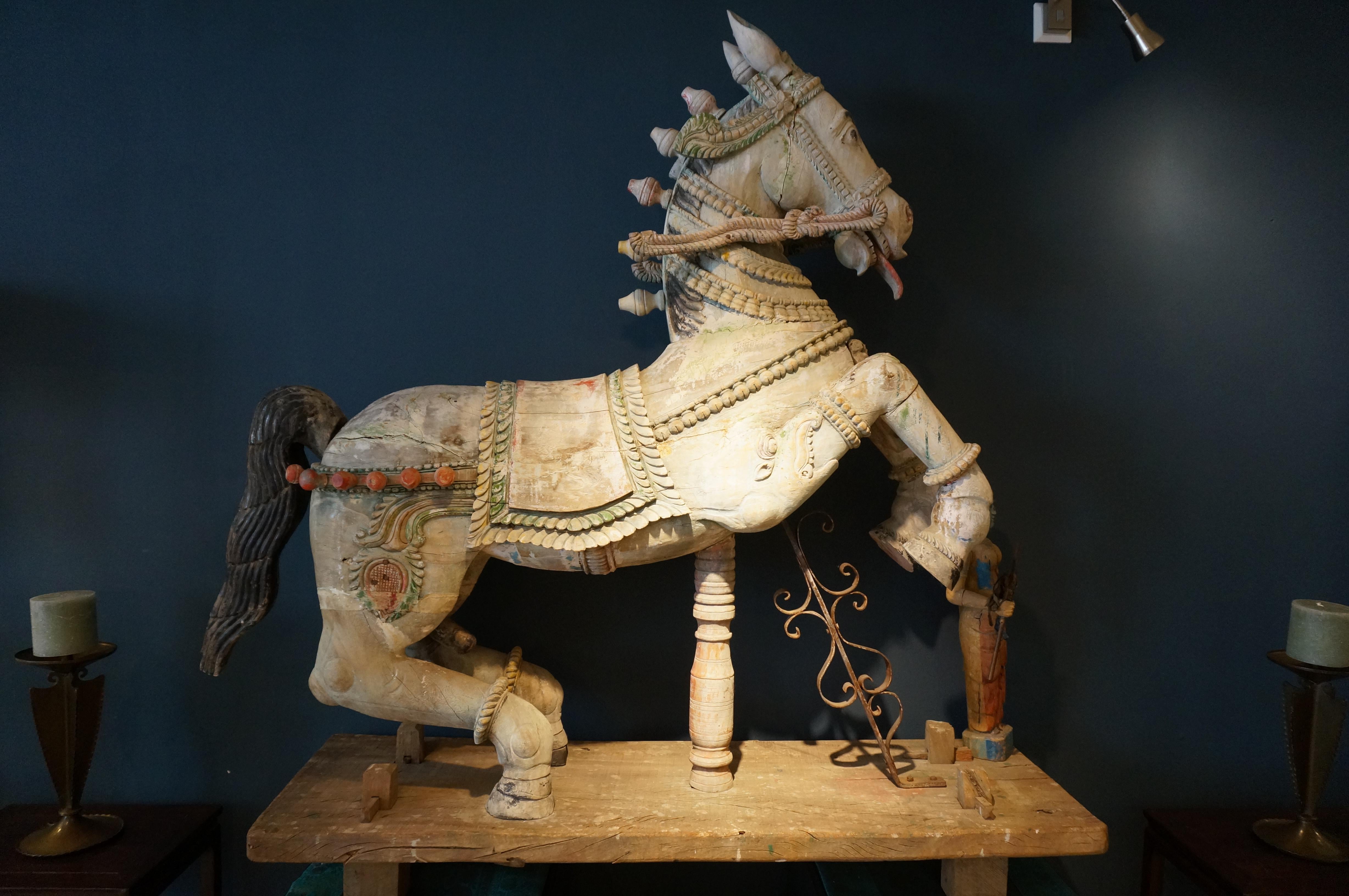 Grande sculpture décorative indienne hindoue en bois représentant un cheval avec un accompagnateur (peut-être Shiva), utilisée pour les processions.

Sculpture sur bois polychrome. En assez bon état, quelques fissures dans le bois et une