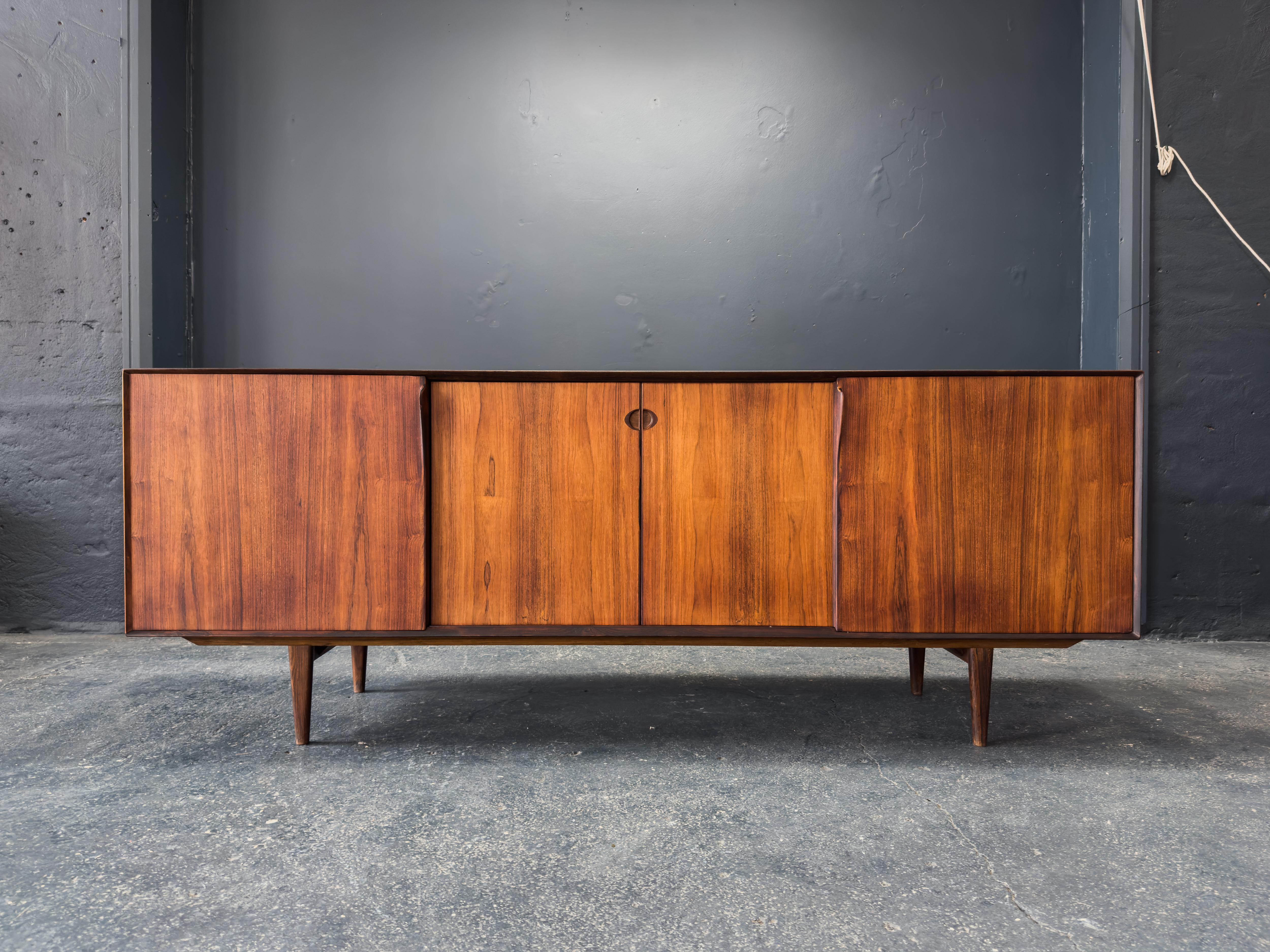 Ce remarquable buffet en bois est un chef-d'œuvre de l'artisanat scandinave, alliant minimalisme raffiné et matérialité audacieuse. Fabriquée en bois richement grainé, la pièce dégage chaleur et profondeur grâce à ses variations naturelles de ton et