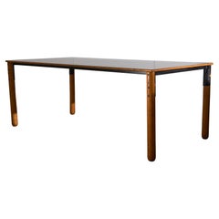 Grande table en bois avec plateau de couleur mate et éléments en métal