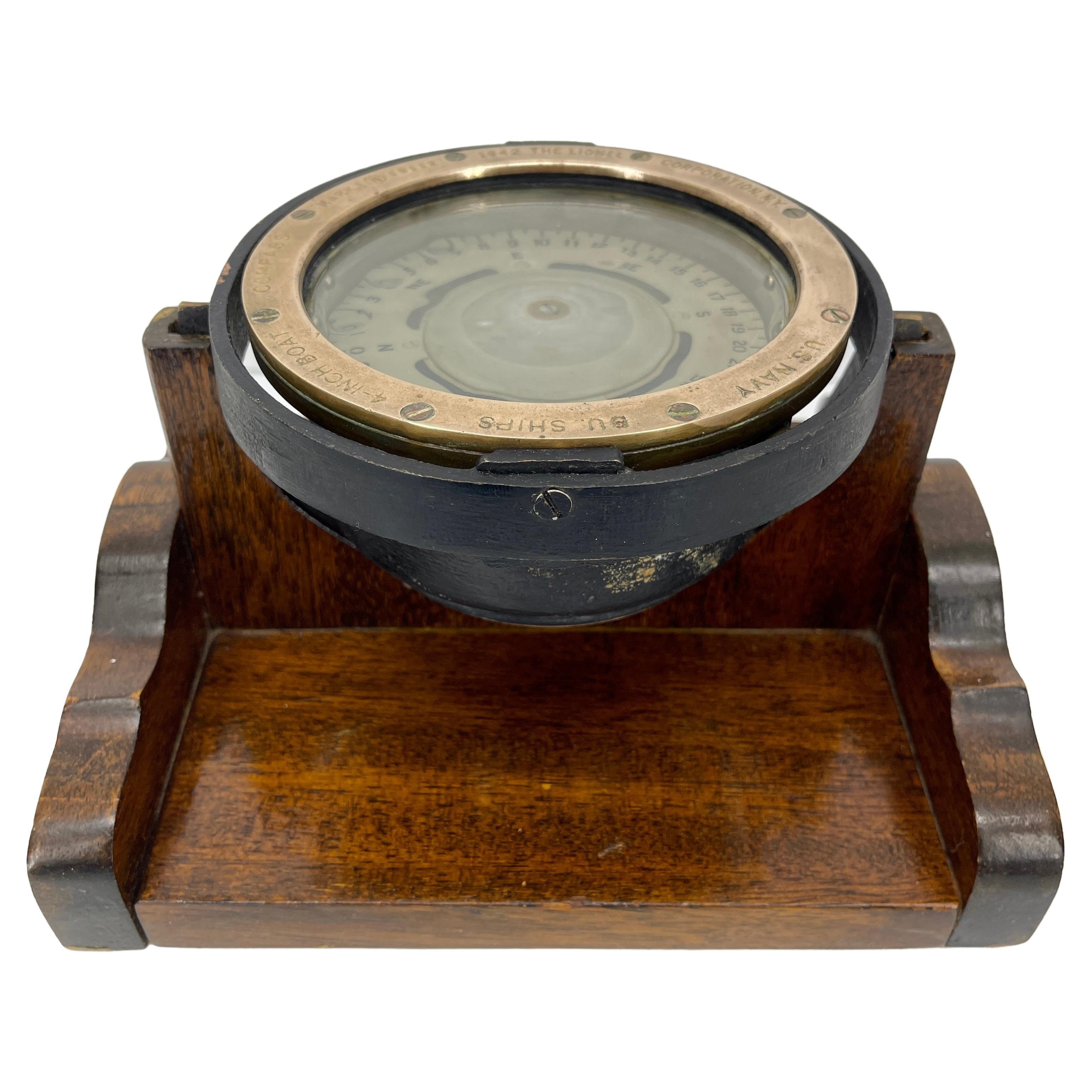 This large United States Navy Bureau of Ships compass is a Mark I 1942 issue.
The compass is in brass and on an oak stand so it can be a desk or shelf accessory.
The top brass disk is engraved with 