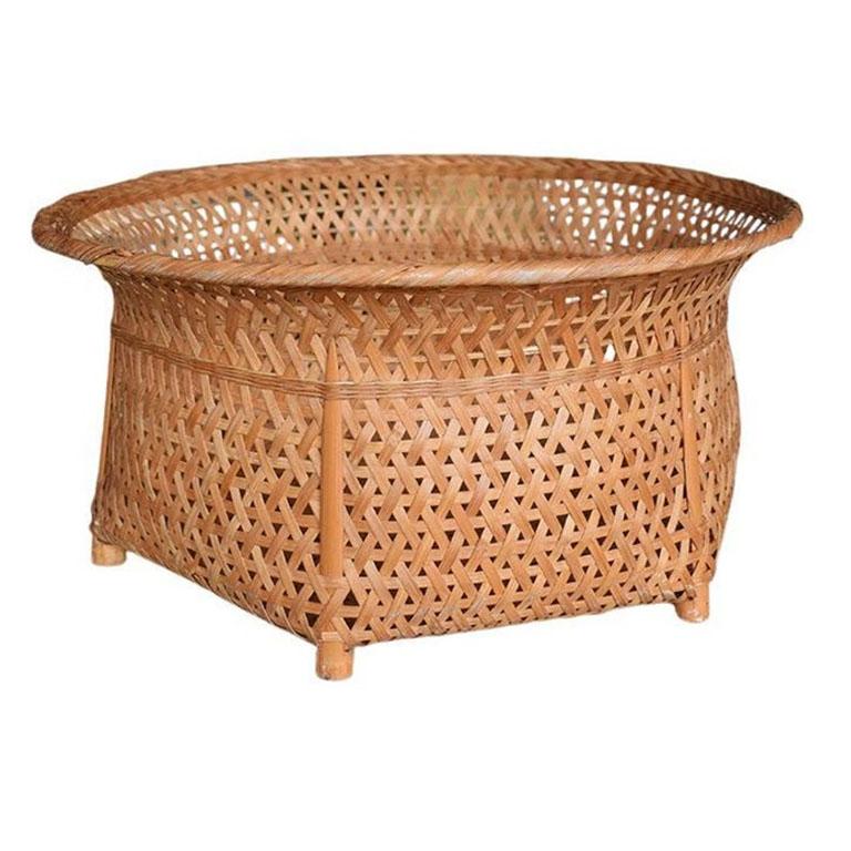 A beautiful chinoiserie woven basket. This piece was found in Hong Kong and is woven of warm brown wicker or rattan. The outsides feature ribs of wood reeds for extra durability. This would be a great piece for storing blankets or magazines. It