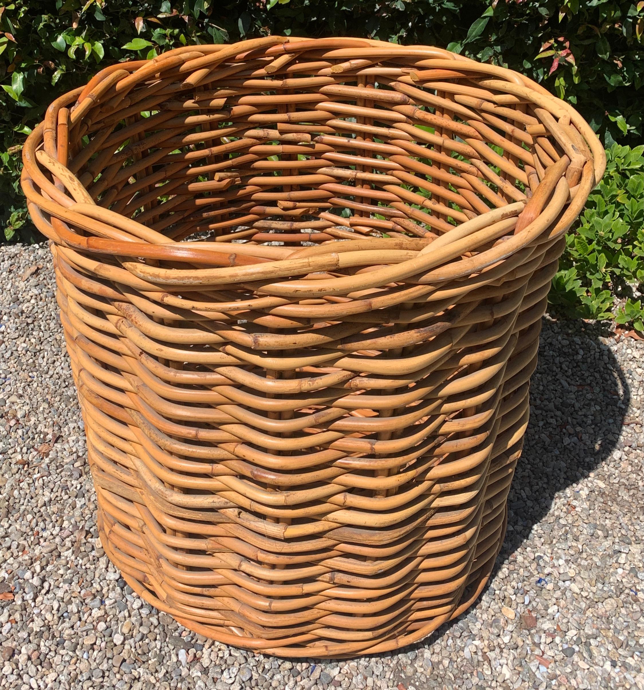 A monumental Rattan Basket. A nicely woven, in very good condition, pencil rattan basket. This piece is huge - well suited for firewood, laundry or games, balls, bats, toys. The basket is substantial and sturdy. A compliment to the mud room, or play