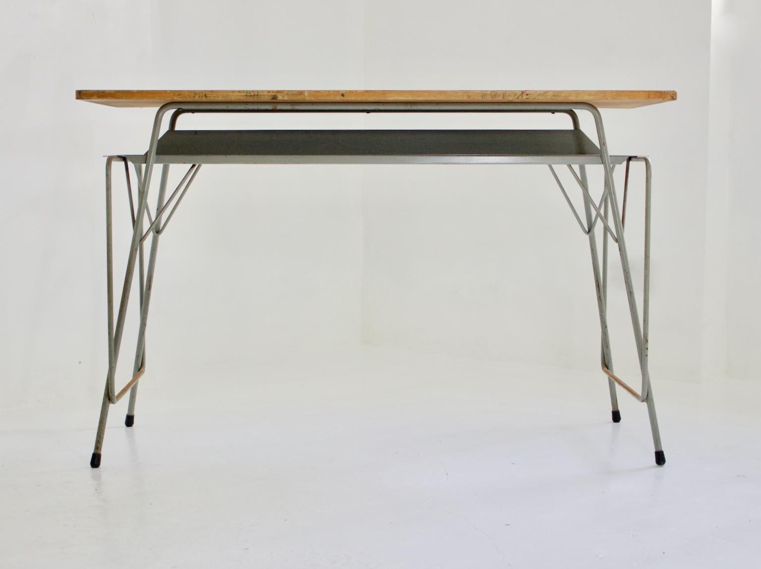 Large mid-century writing desk by Belgian architect and designer, Willy Van Der Meeren, 1950s.

French grey steel base and storage shelf, with plywood top and interesting detailing to the legs. 

The piece has come from a Belgian school and is