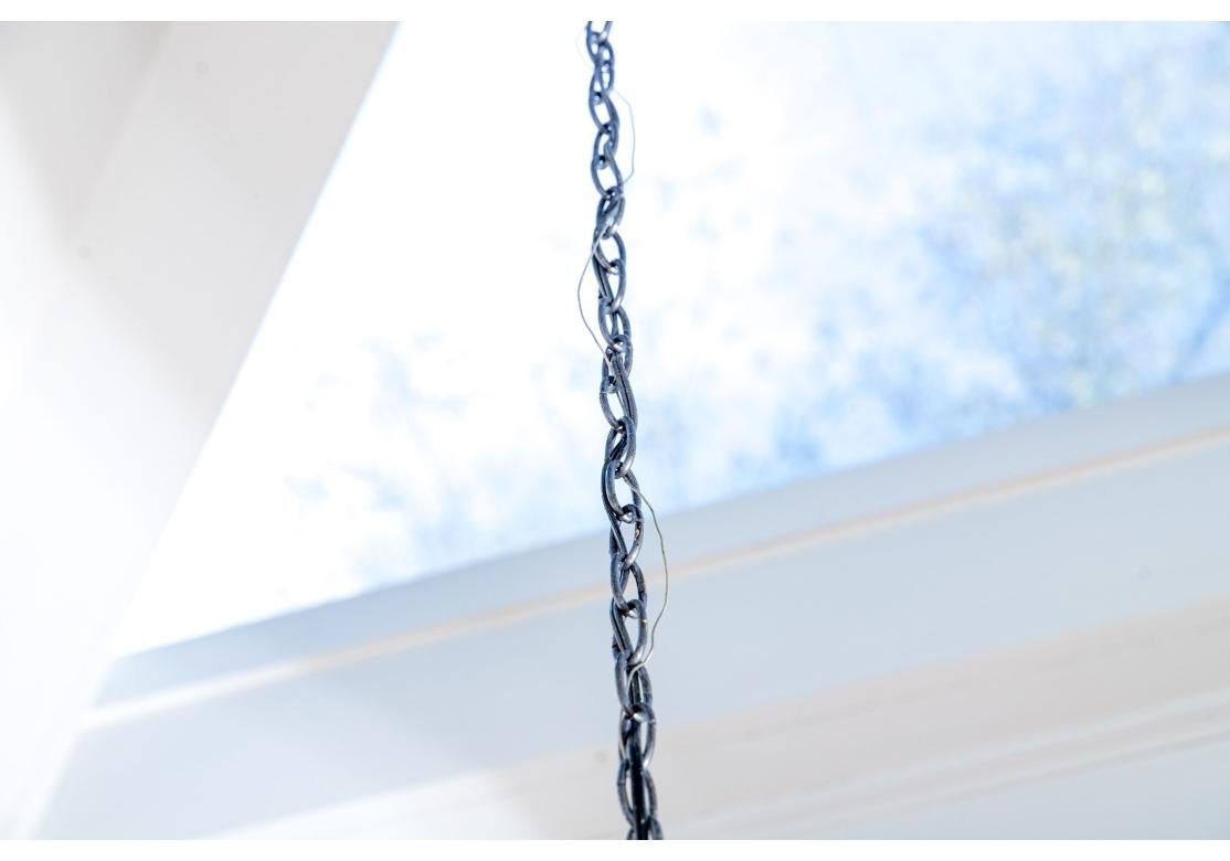 Lustre en fer forgé en forme de cage d'oiseau avec 12 bras à volutes, une bobèche cannelée et des couvercles de bougie en nid d'abeille. Le lustre est équipé d'un terminal à anneau, d'une suspension enroulée, d'un capuchon de plafond et de 84