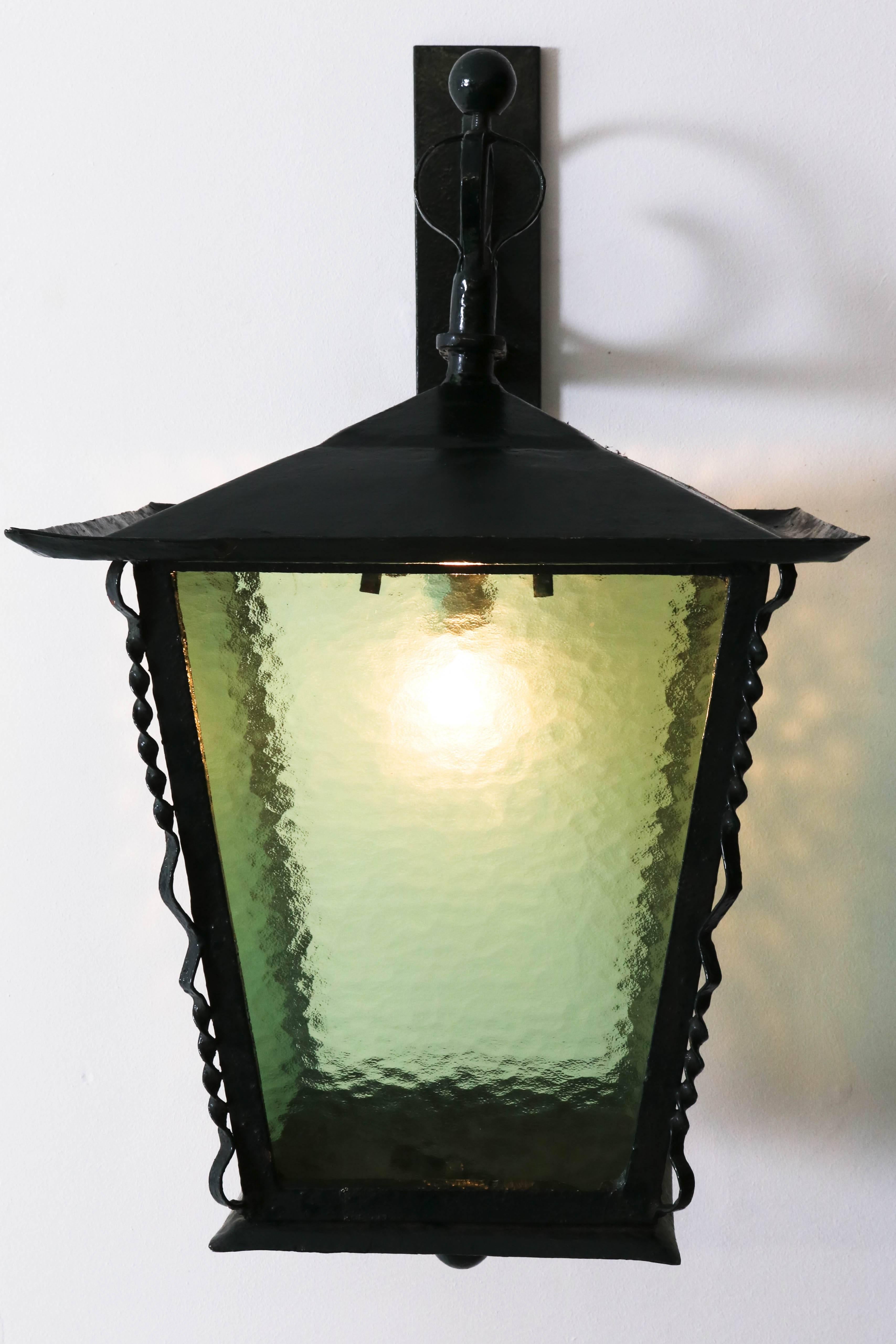 Large and rare wrought iron Art Deco Amsterdam School wall-mounted lantern, 1920s.
Four original green glass shades.
Rewired with one socket for E-27 light bulb.
In good original condition with minor wear consistent with age and use,
preserving