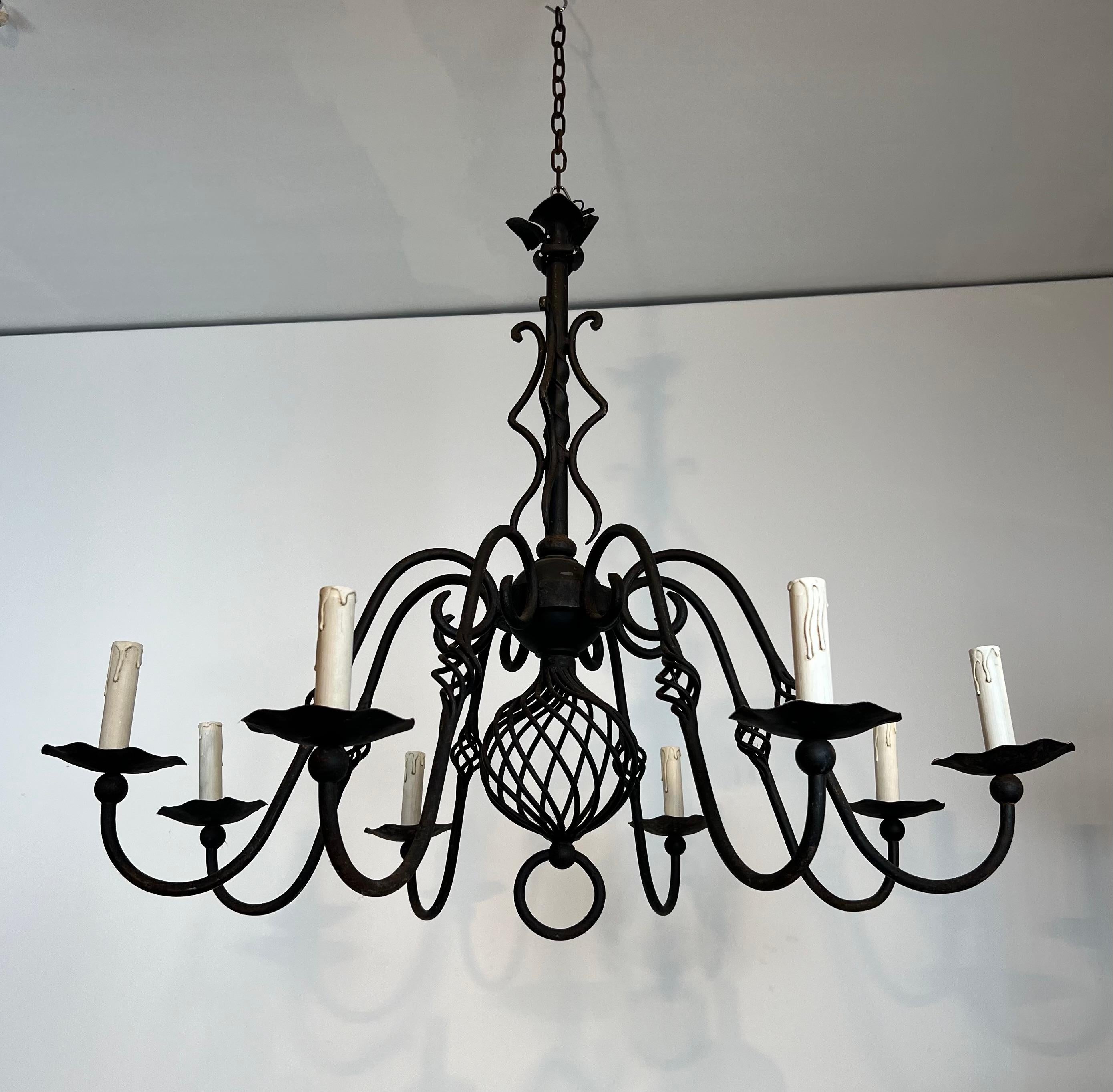 Esta bonita lámpara de araña grande de 8 luces es de hierro forjado. Se trata de una obra francesa de estilo gótico. Alrededor de 1950
