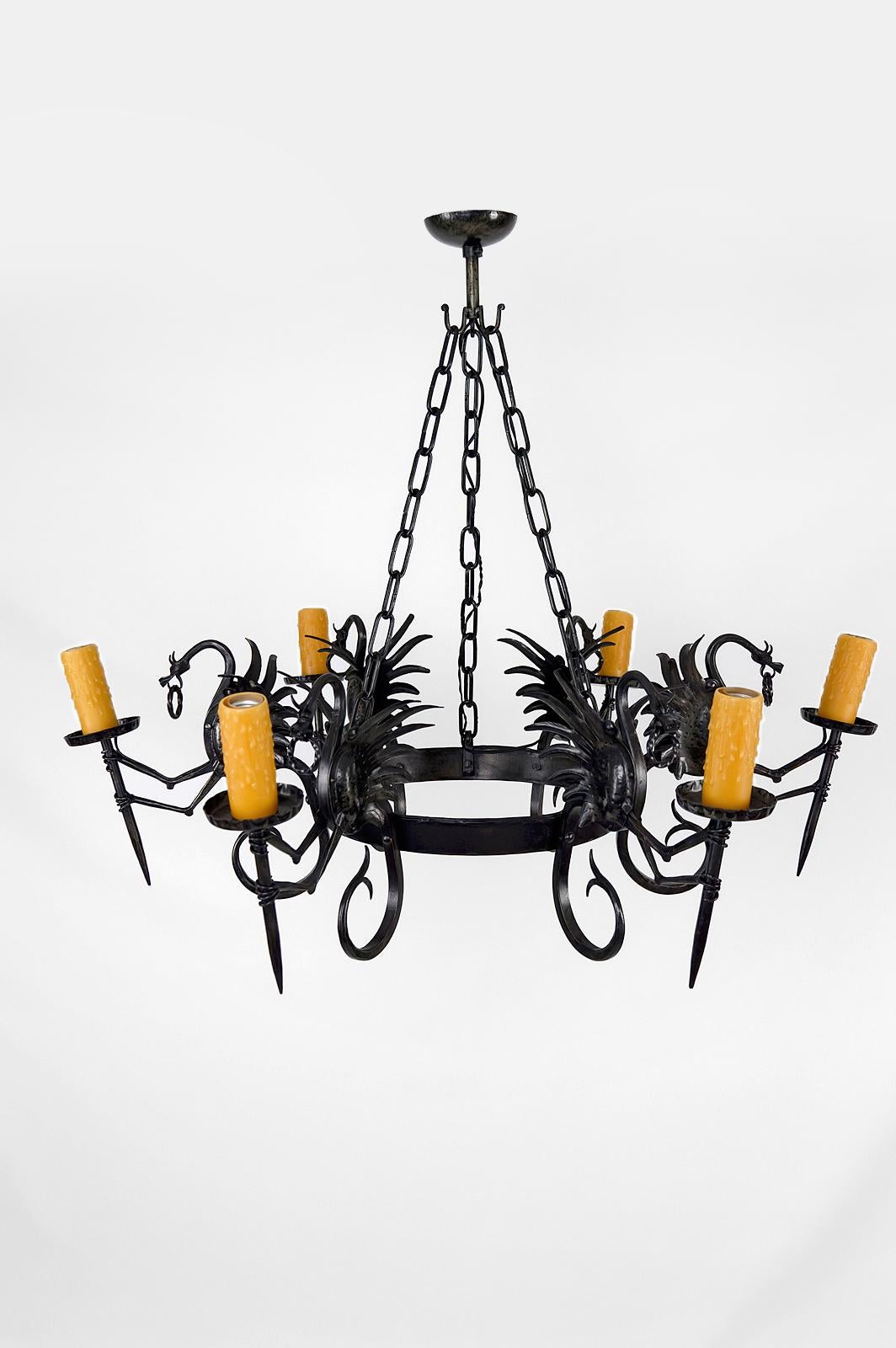 Superb and impressive wrought iron chandelier / pendant composed of 6 winged dragons each holding a torch / torchiere.

Good quality of manufacture: well-made subjects, beautiful patina of the metal.

Neo-Gothic / Art Nouveau / Liberty style, Italy,
