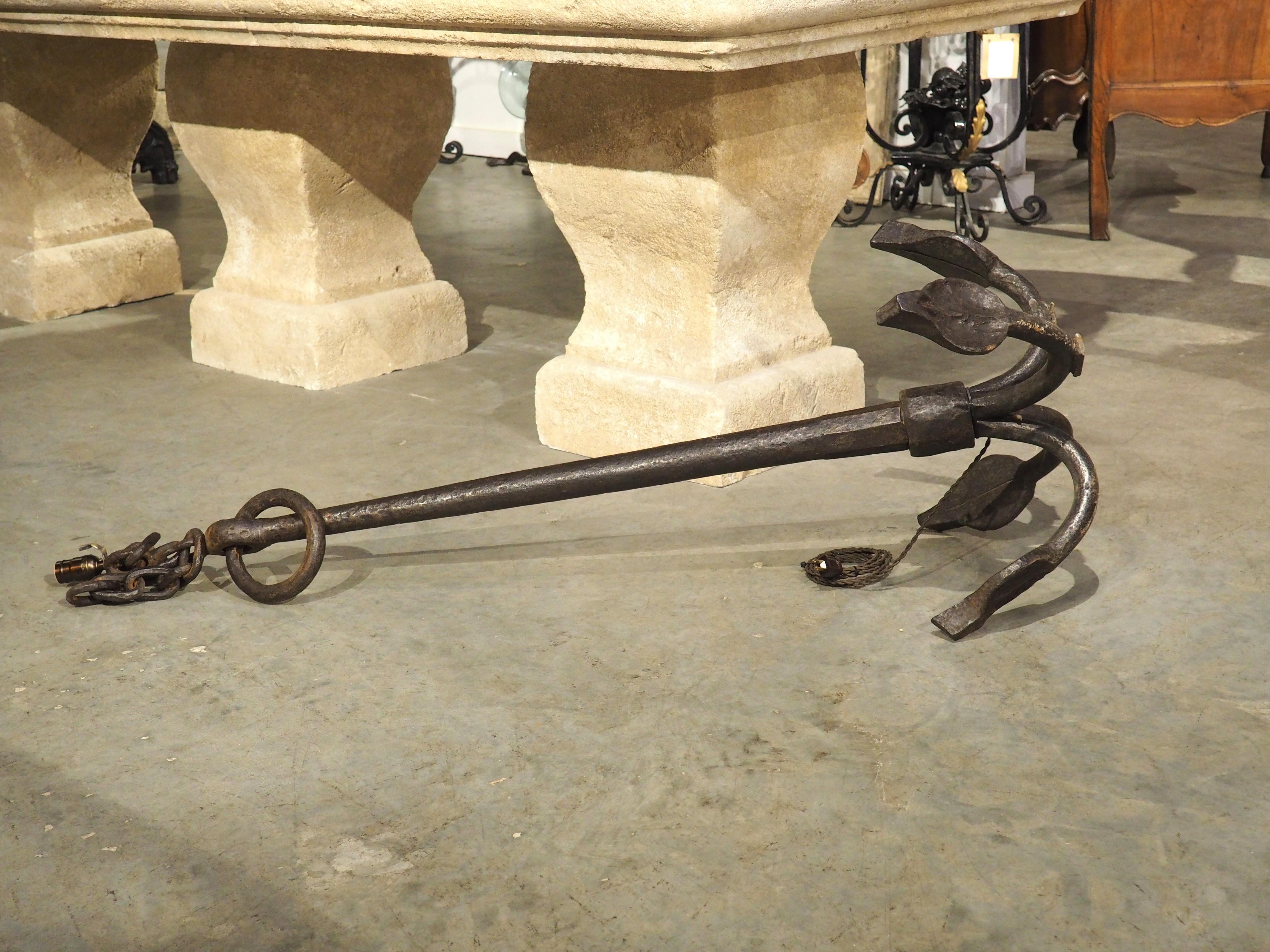 A unique source of illumination, this large wrought iron boat anchor has been fitted with a lamp socket and harp. Originally from France (1800s), the stockless grapnel style anchor has a wonderful light patination of oxidation from exposure to the