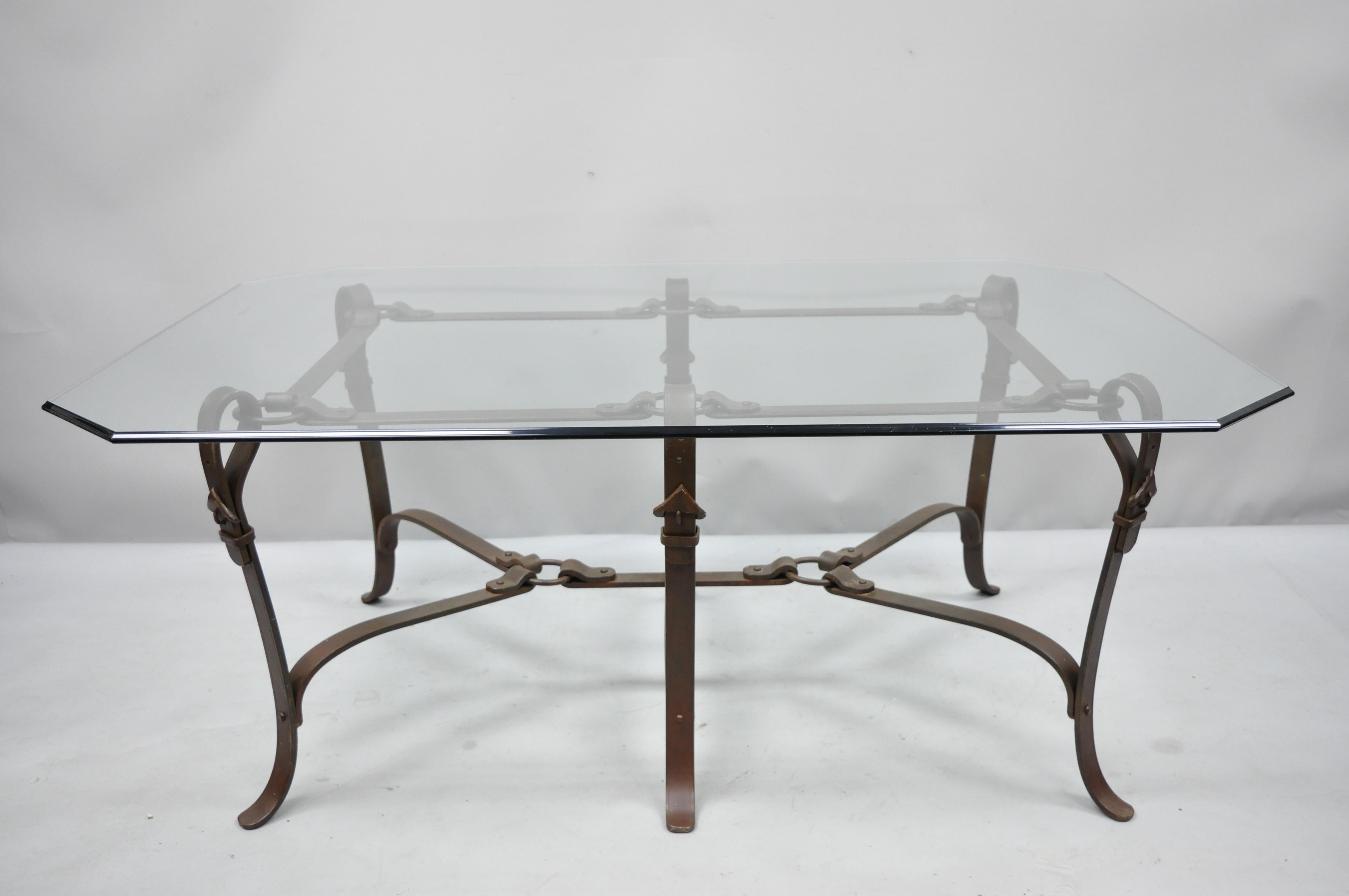 Large wrought iron Horsebit & Belt form glass top coffee table. Item features heavy iron base, leather belt and horsebit design, 6 legs, beveled glass top, great style and form, circa late 20th century. Measurements: 23