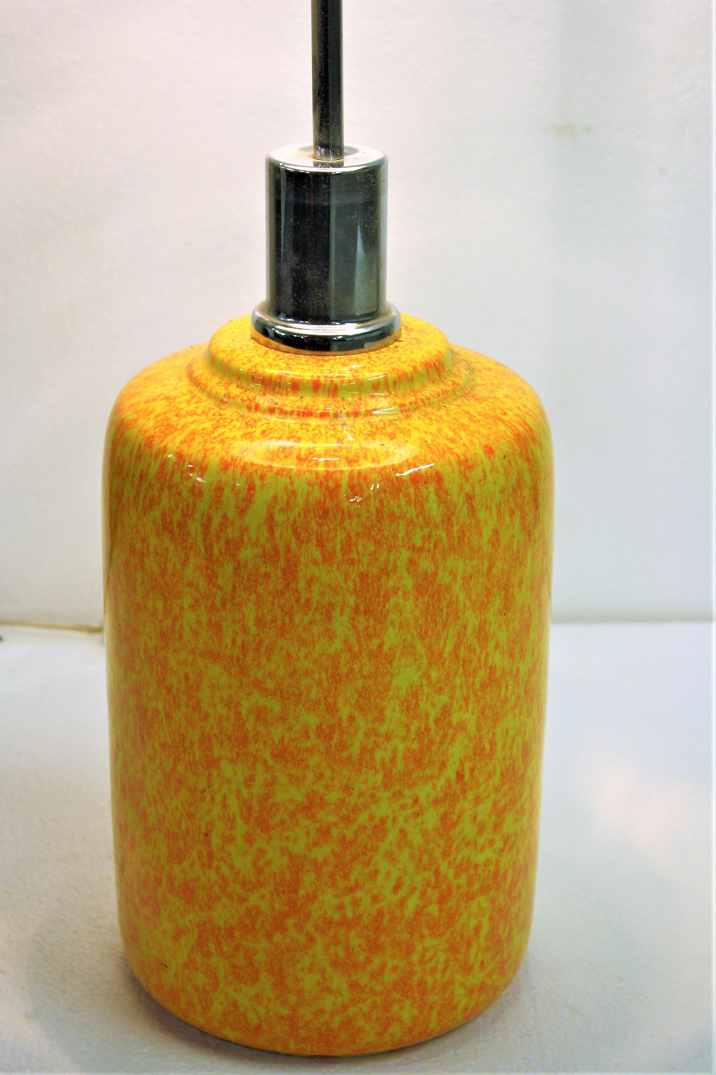 Midcentury yellow and orange stained ceramic table lamp.

The table lamp is unusually high with a chromed steel rod.

This colorful lamp is in good condition, without any chips or damages.

Tested and ready for use with a regular E26/E27 light