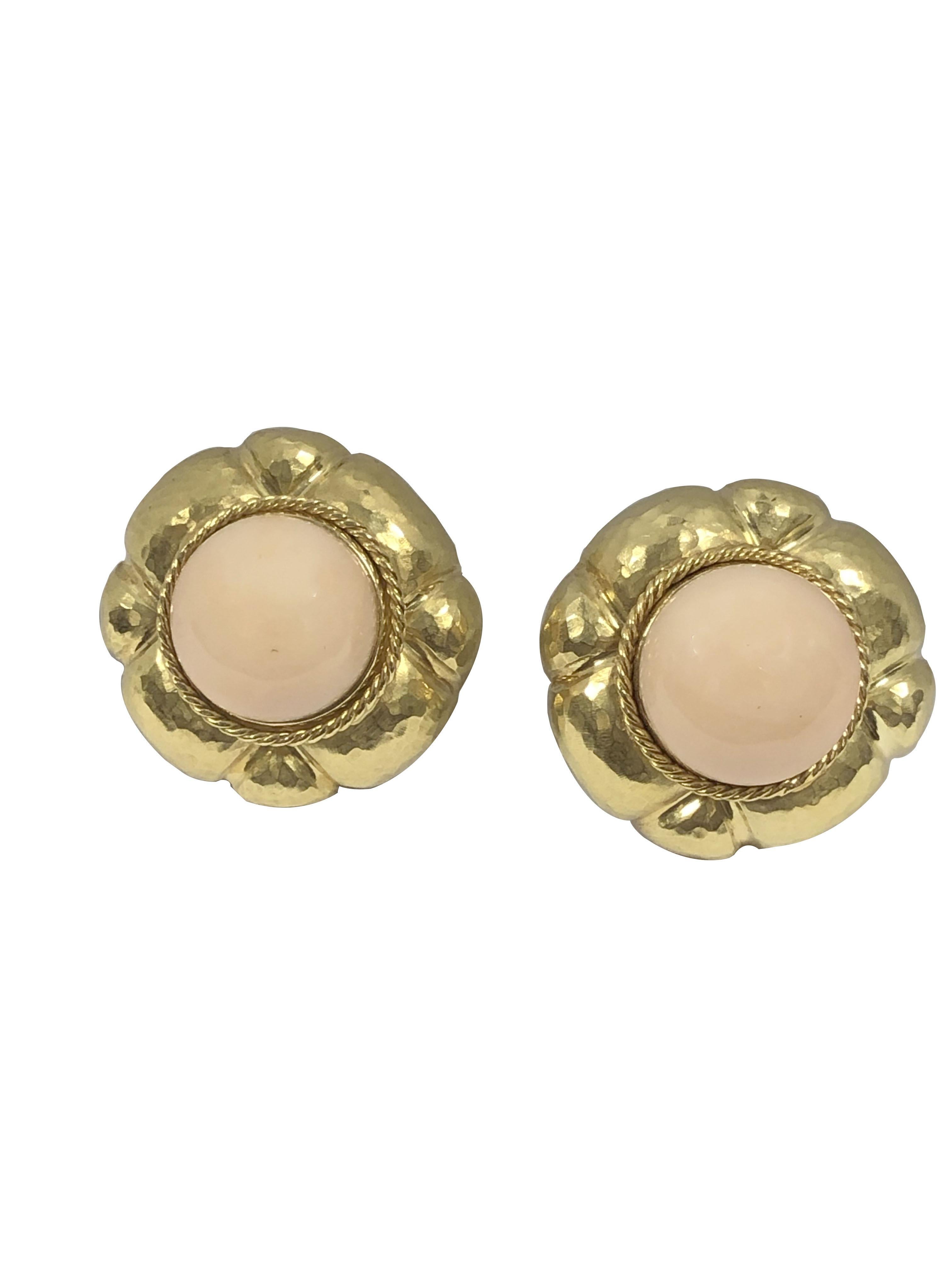Circa 1990s 18K Yellow Gold Hand Hammered Earrings, measuring 1 1/8 inches in diameter, centrally set with a Light Pink Angel Skin Coral Button measuring 16 M.M. within a twisted Rope Border. Omega clip backs with a Post. 