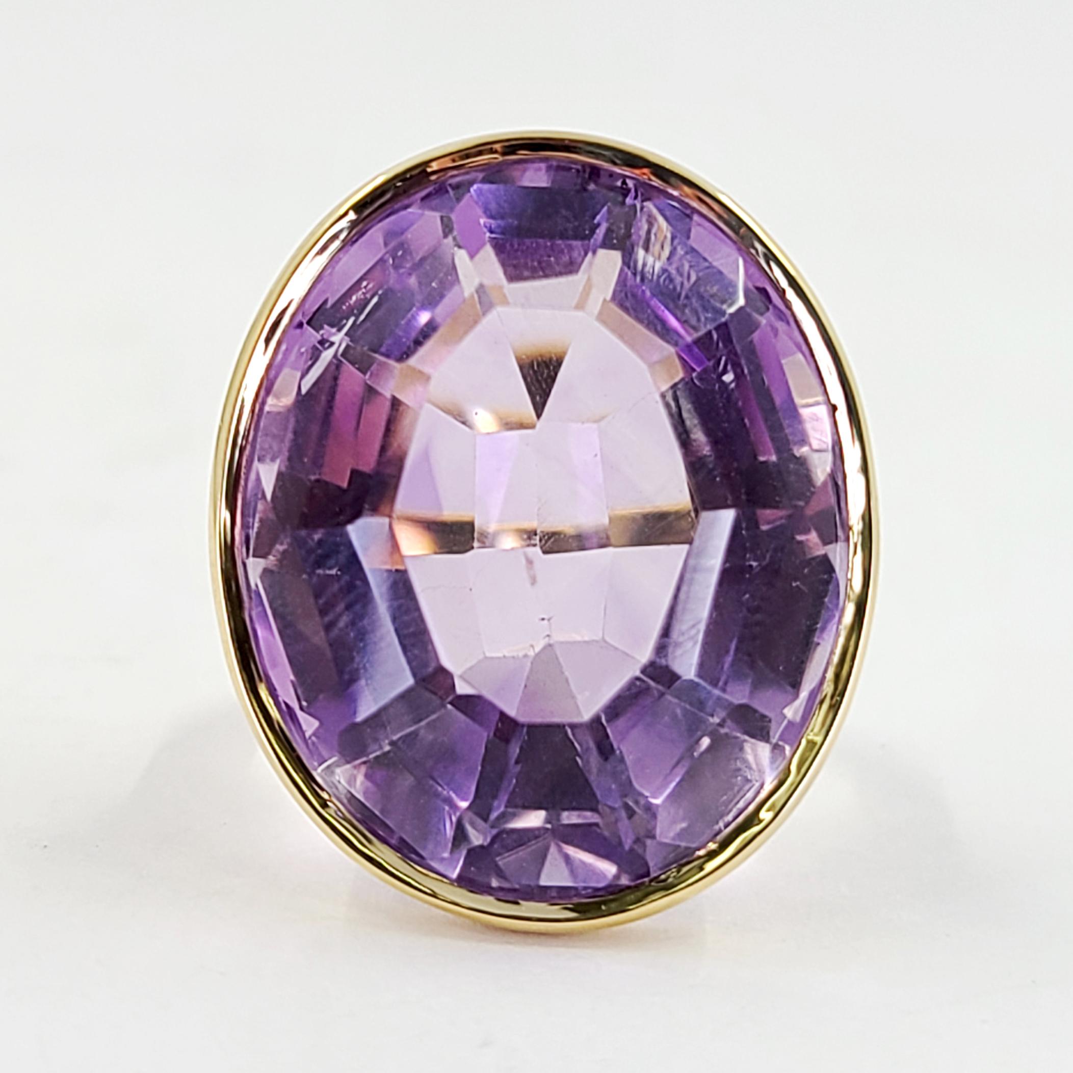 18 Karat Yellow Gold Cocktail Ring Featuring A 35 Carat Bezel Set Oval Amethyst. Finger Size 5; Purchase Includes One Sizing Service. Finished Weight Is 13.7 Grams.