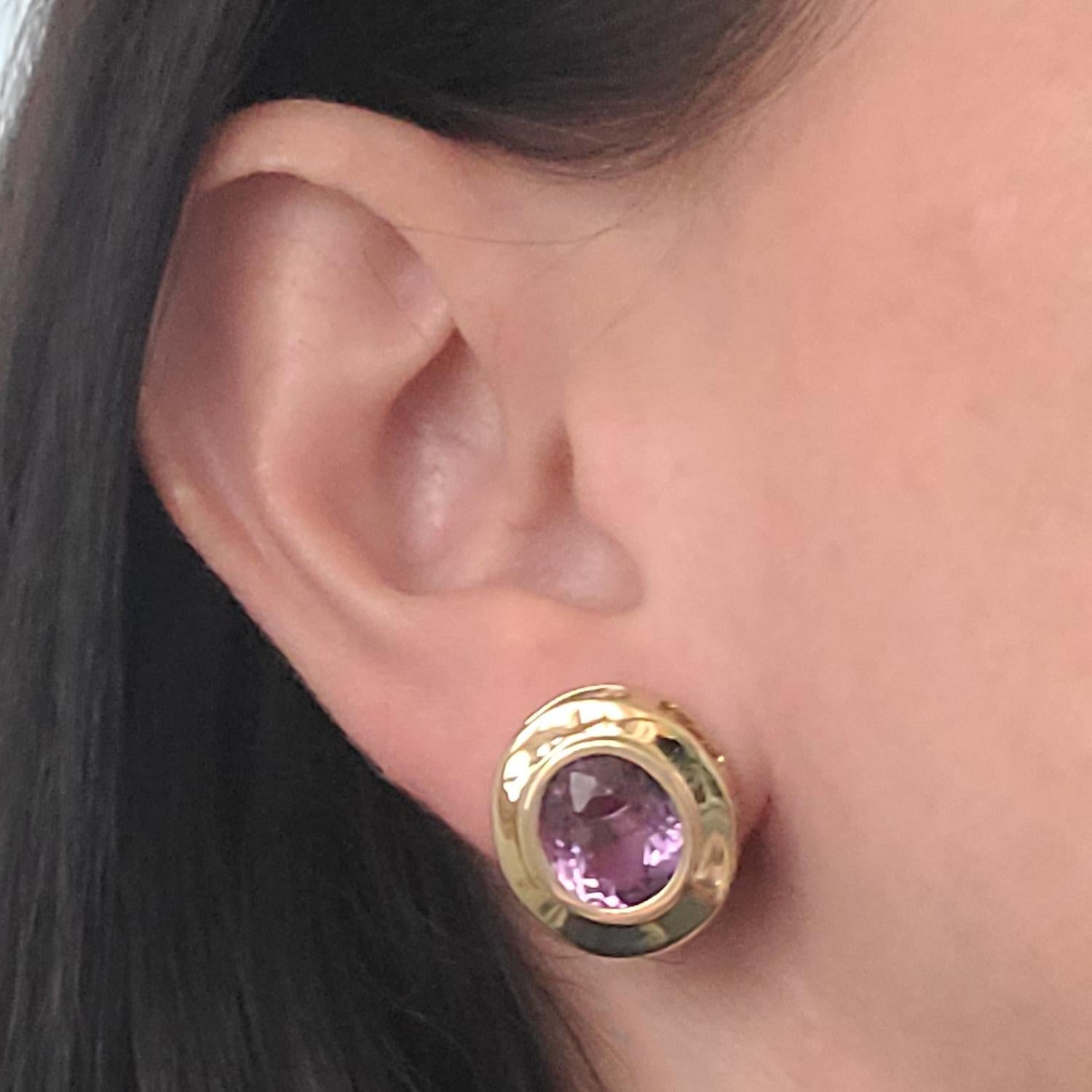 14 Karat Yellow Gold Bezel Stud Earrings Featuring 2 Oval Amethysts Totaling Approximately 6.50 Carats. Pierced Post with Friction Backs. Finished Weight Is 7.0 Grams.