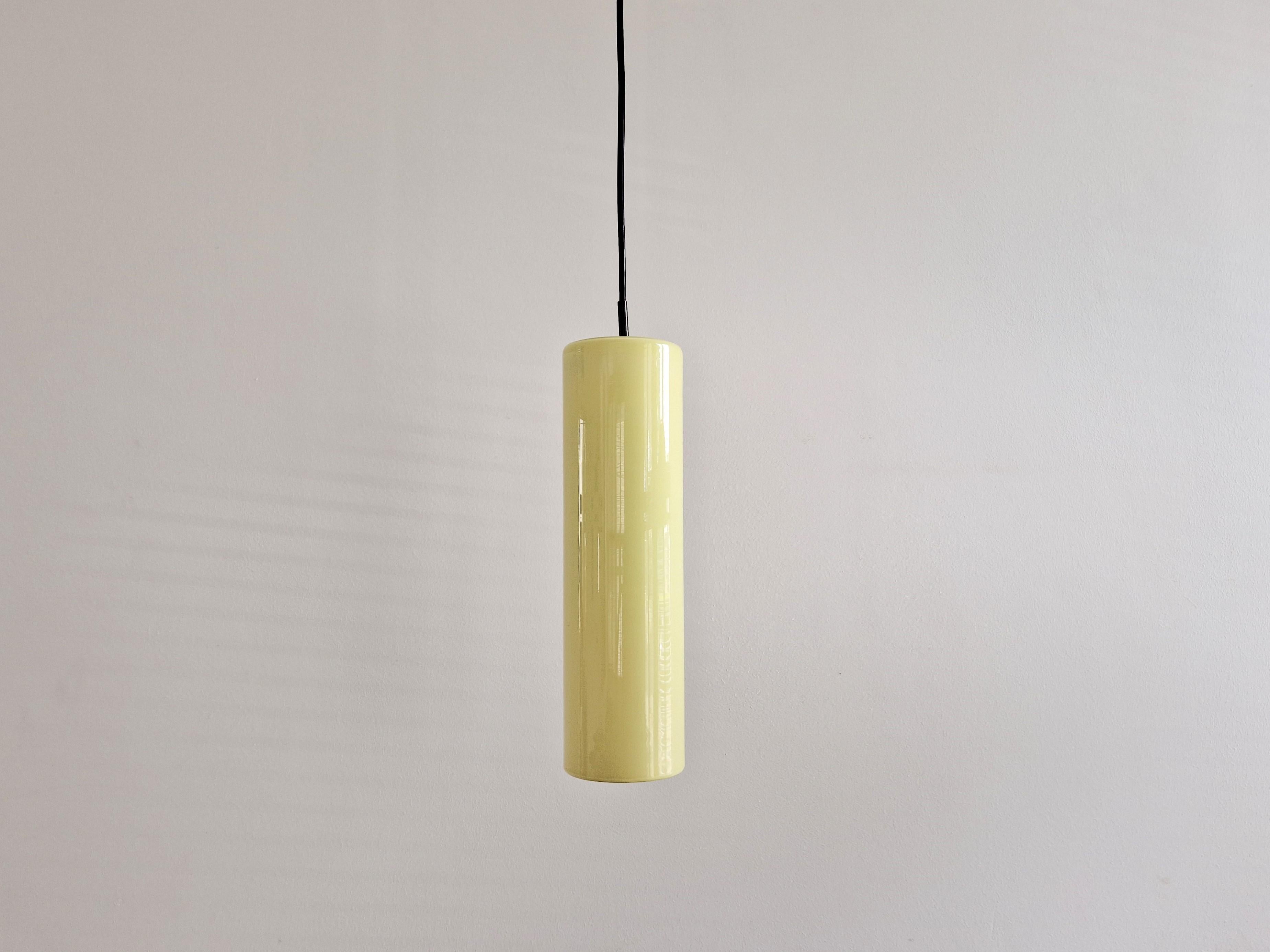 Cette lampe suspendue cylindrique en verre jaune a été conçue par Massimo Vignelli pour Venini dans les années 1960. Il a été fabriqué en 2 tailles avec une hauteur de 30 cm et 40 cm. Cette lampe est la version la plus grande et la plus rare. Elle
