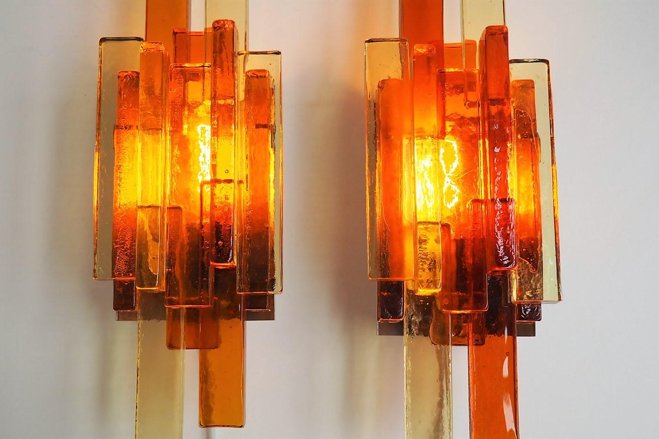 Pair of large sconces made in thick elongated square glass pieces in yellow and orange colors. They are designed by Holm Sørensen in the 1960s.

There is a little chip on one glass piece - please see the last picture.
 
Both lamps have been