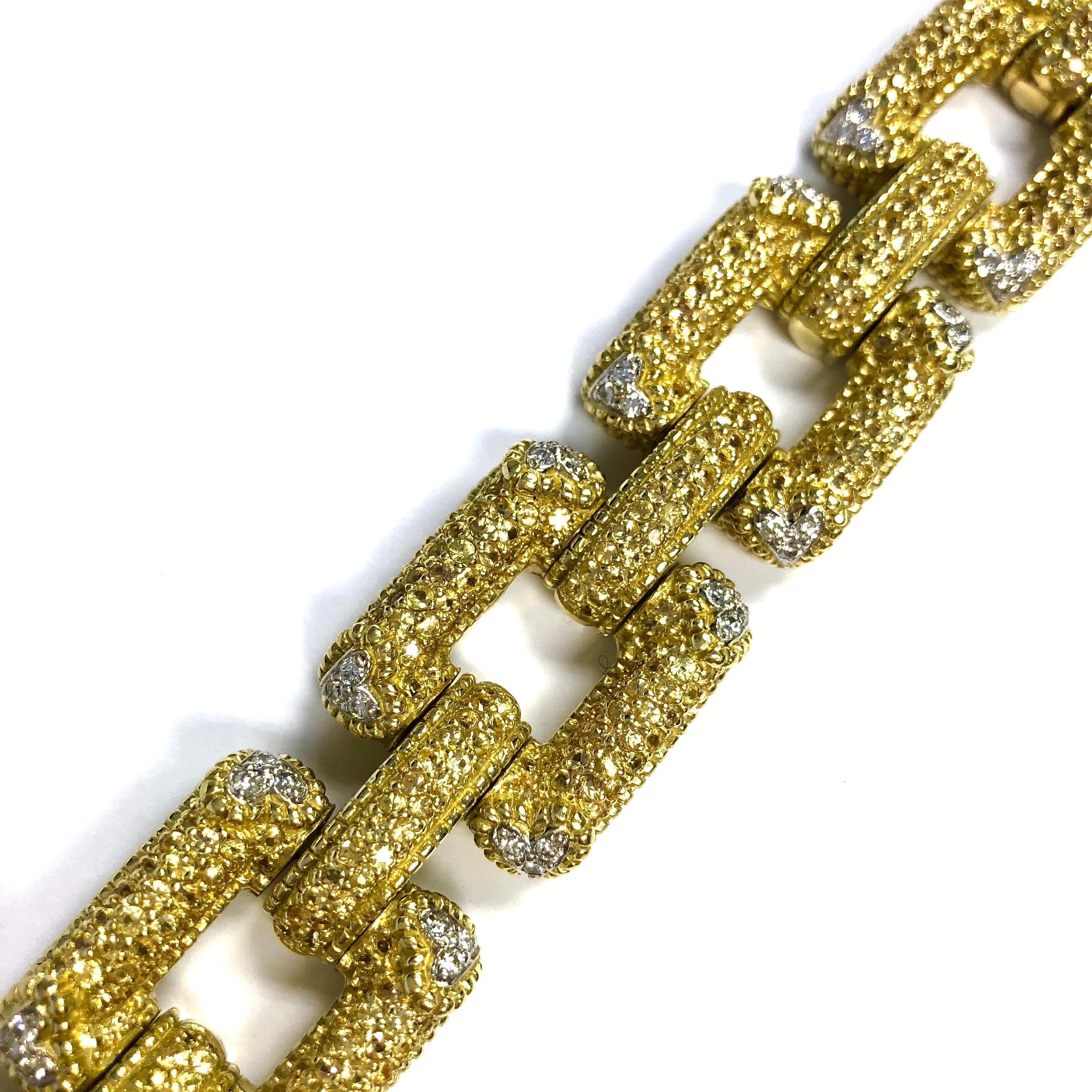 Crafted in 18K yellow gold, this magnificent bracelet is fully pave set on the front with approximately 10 carats of round cut natural yellow sapphires and 1.75 carats of round brilliant cut diamonds. Diamond Color: F-G, Clarity: