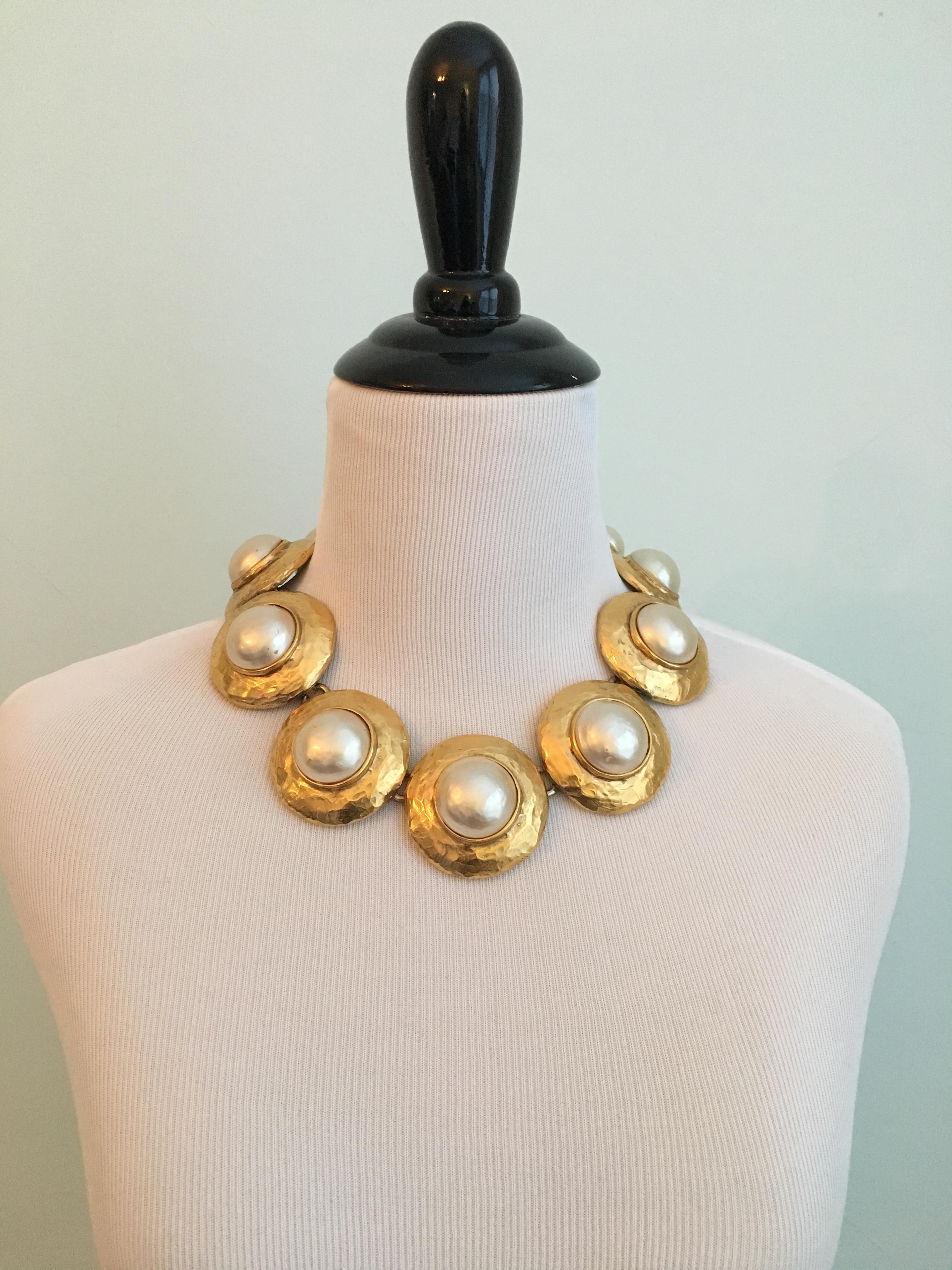 Striking 1980s Yves Saint Laurent necklace made up of large gold plated disks with faux pearl centers made by Goossens. The faux pearls are coated in a thick pearl nacre which give them a beautiful luminous quality. The necklace is adjustable and