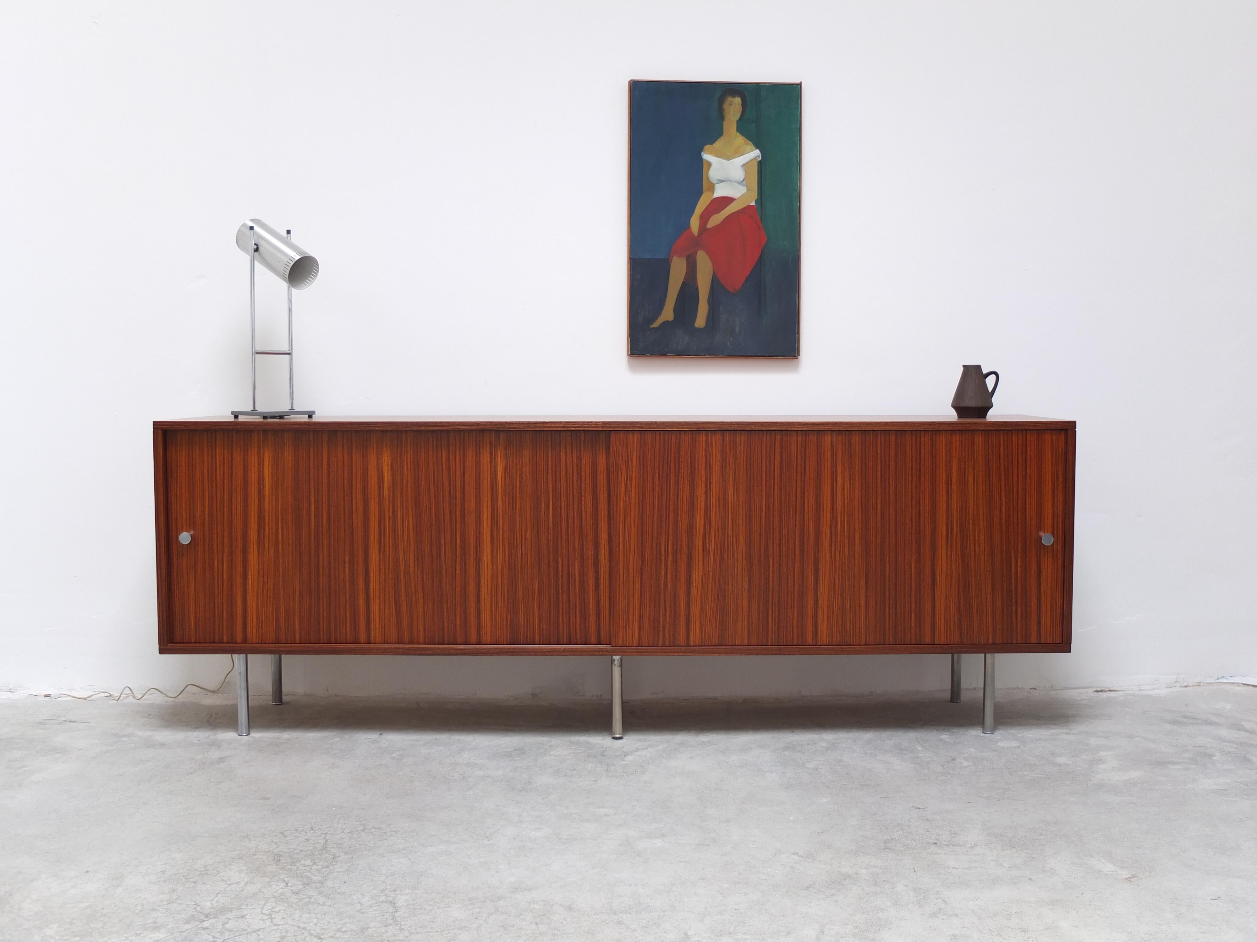 Large minimalist sideboard designed by Alfred Hendrickx for Belform, 1960s. Finished in a decorative Zebrano (or Zingana) wood veneer with round metal feet and cone shaped metal door handles. In mint restored condition. We have a matching secretary