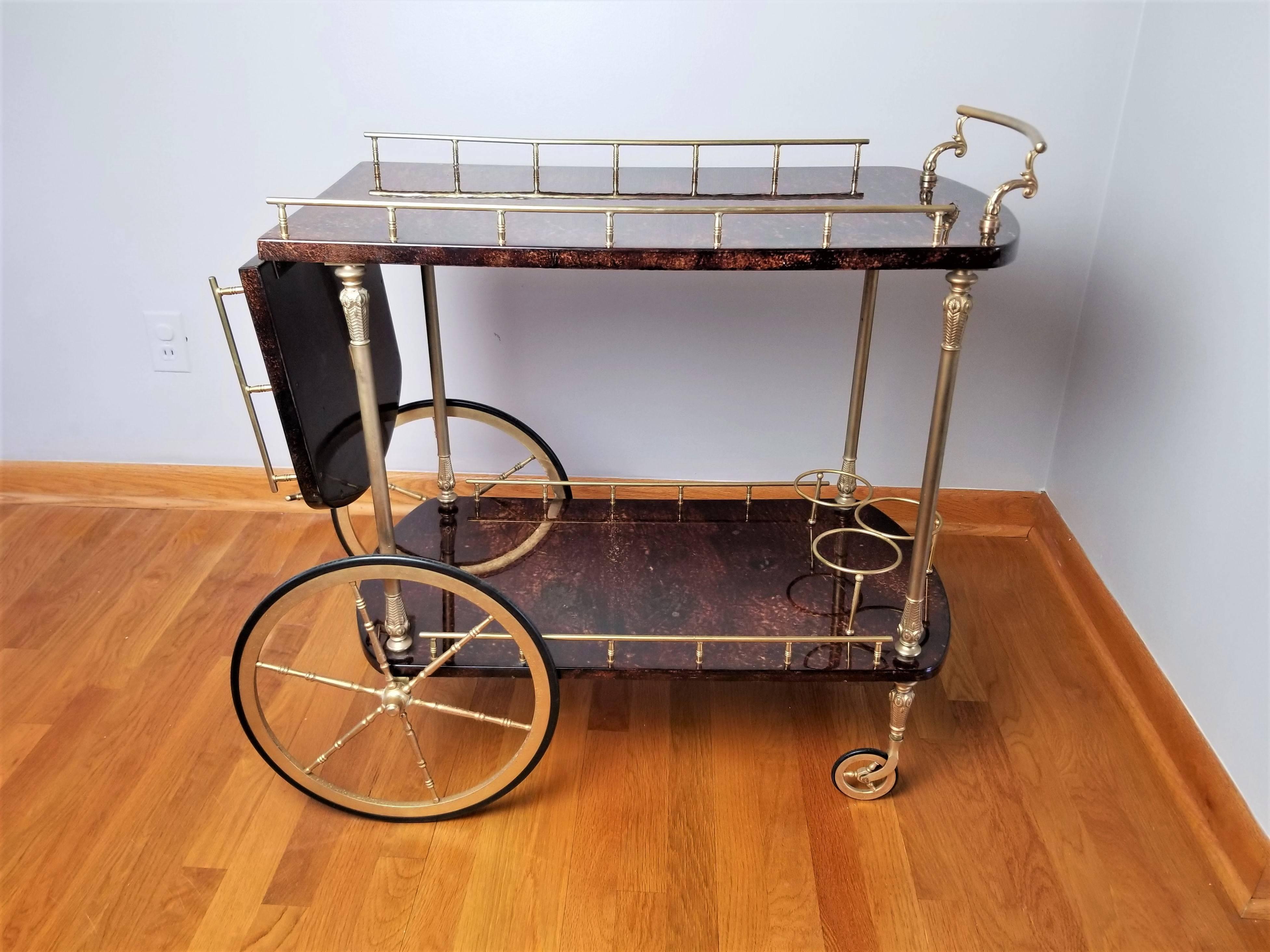 Handsome rich brown lacquered goatskin or parchment bar cart with brass details by Aldo Tura, Italy, circa 1950s. Dimensions with leaf dropped are 
31.5