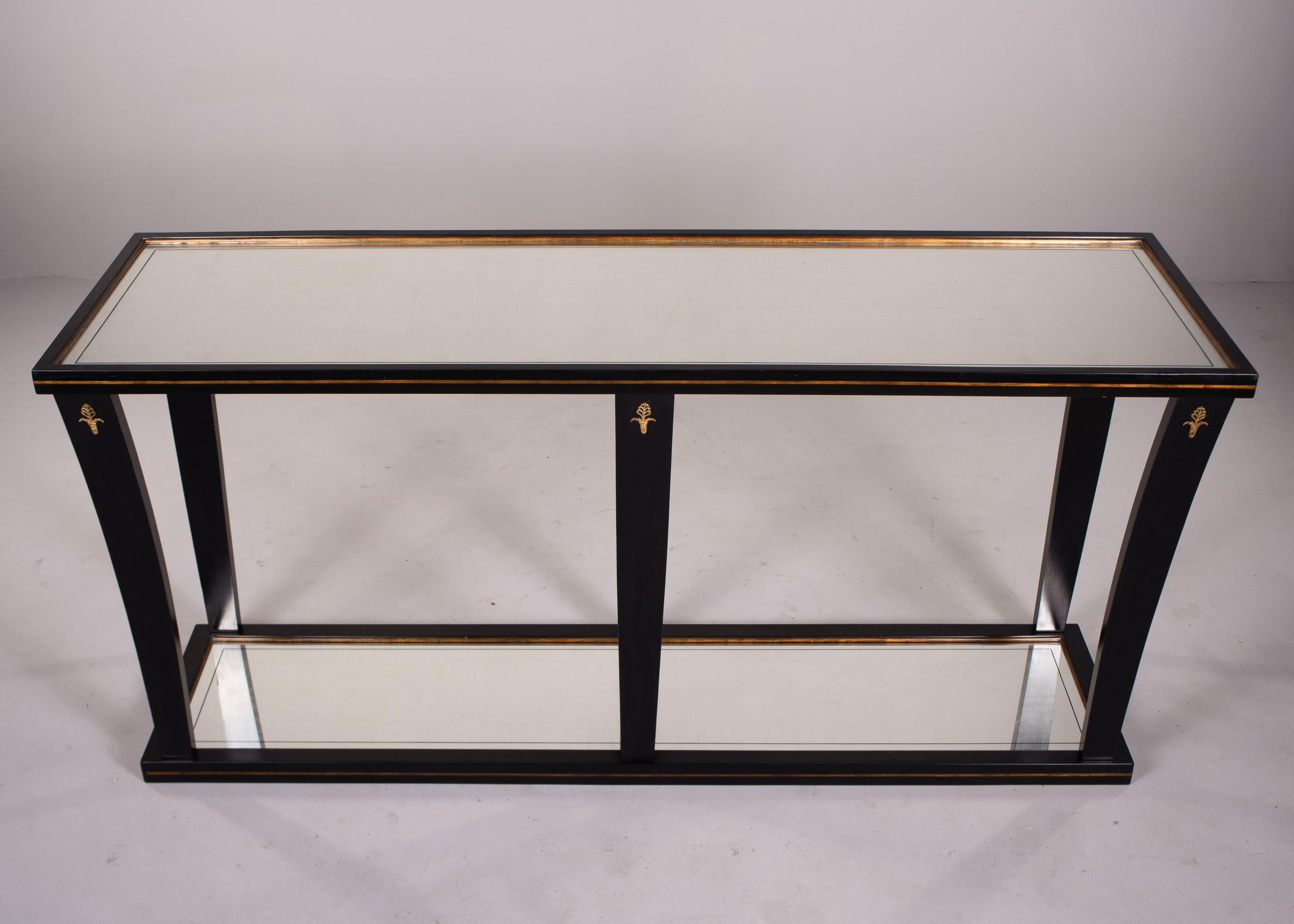Found in France, this large scale console by La Grange dates from the 1940s. Console features a mirrored top and bottom shelf, six legs, brass trim and a black lacquer finish. Very good overall vintage condition with minor scattered surface wear. 