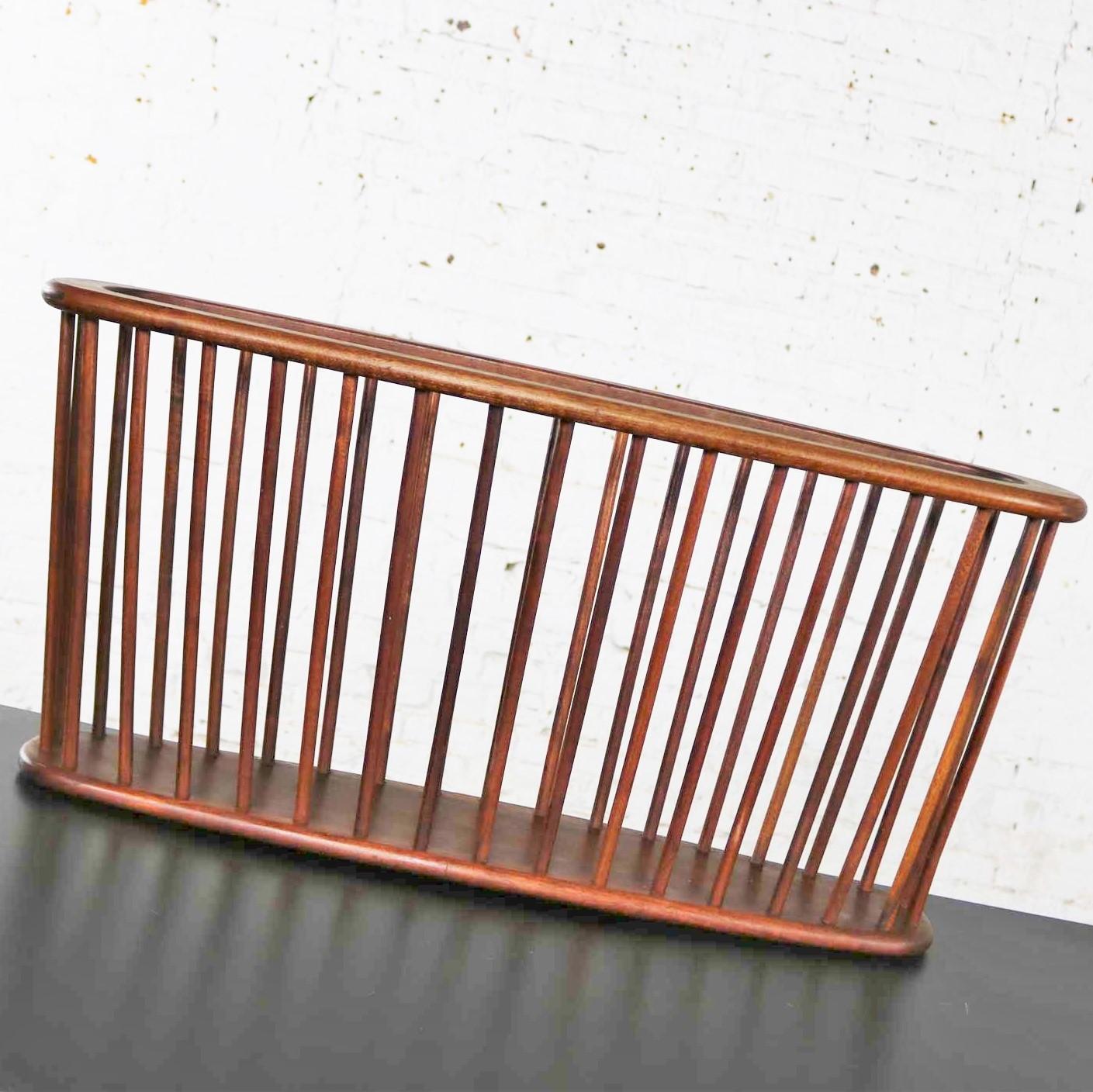 Handsome walnut oval magazine rack in the larger size attributed to Arthur Umanoff for Washington Woodcraft. It is in fabulous original condition which we have just given a good cleaning and oiling. Please see photos, circa 1960s.

If you need a
