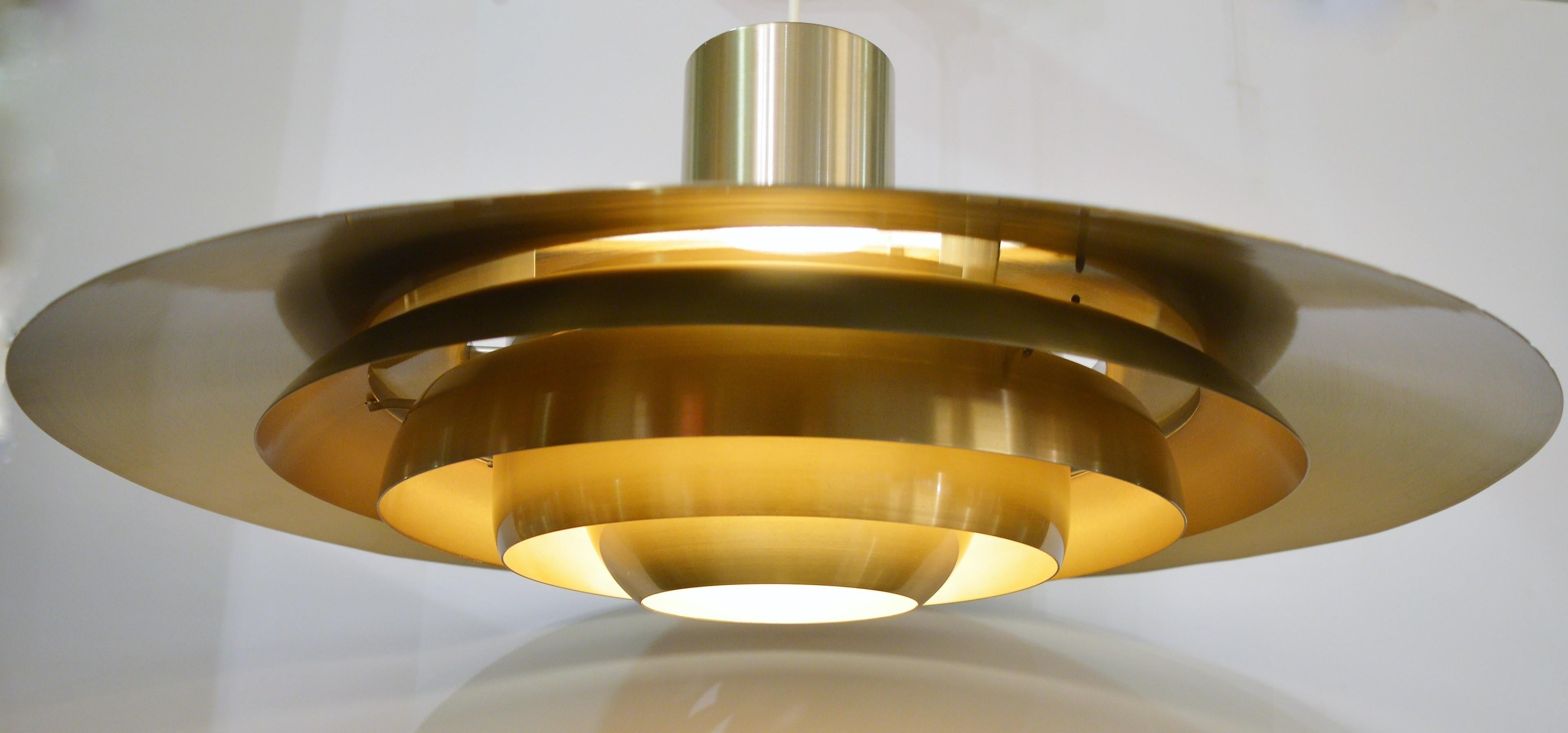 A wonderful Danish modern large scale multi-tier pendant that offers impressive impact and yet a slimmer side profile. Designed by Jørgen Kastholm & Preben Fabricius for Nordisk Solar Compagni, Denmark, 1960s. Made of lightly brassed spun aluminium