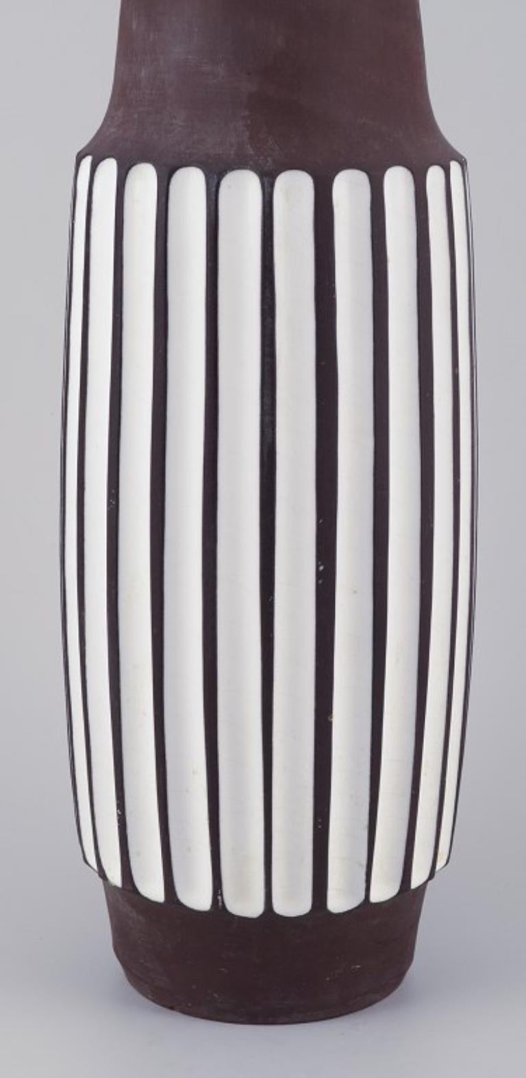 PRE-OWNED GOODS ARE EXEMPT FROM IMPORT TARIFFS FOR U.S., UK, AUSTRALIAN & CANADIAN CUSTOMERS.   
THEREFORE, NO IMPORT TARIFFS WILL BE APPLICABLE TO YOUR PURCHASE. 

Larholm, Norway.
Floor vase made of ceramic.
Modernist design.
Vertical lines.