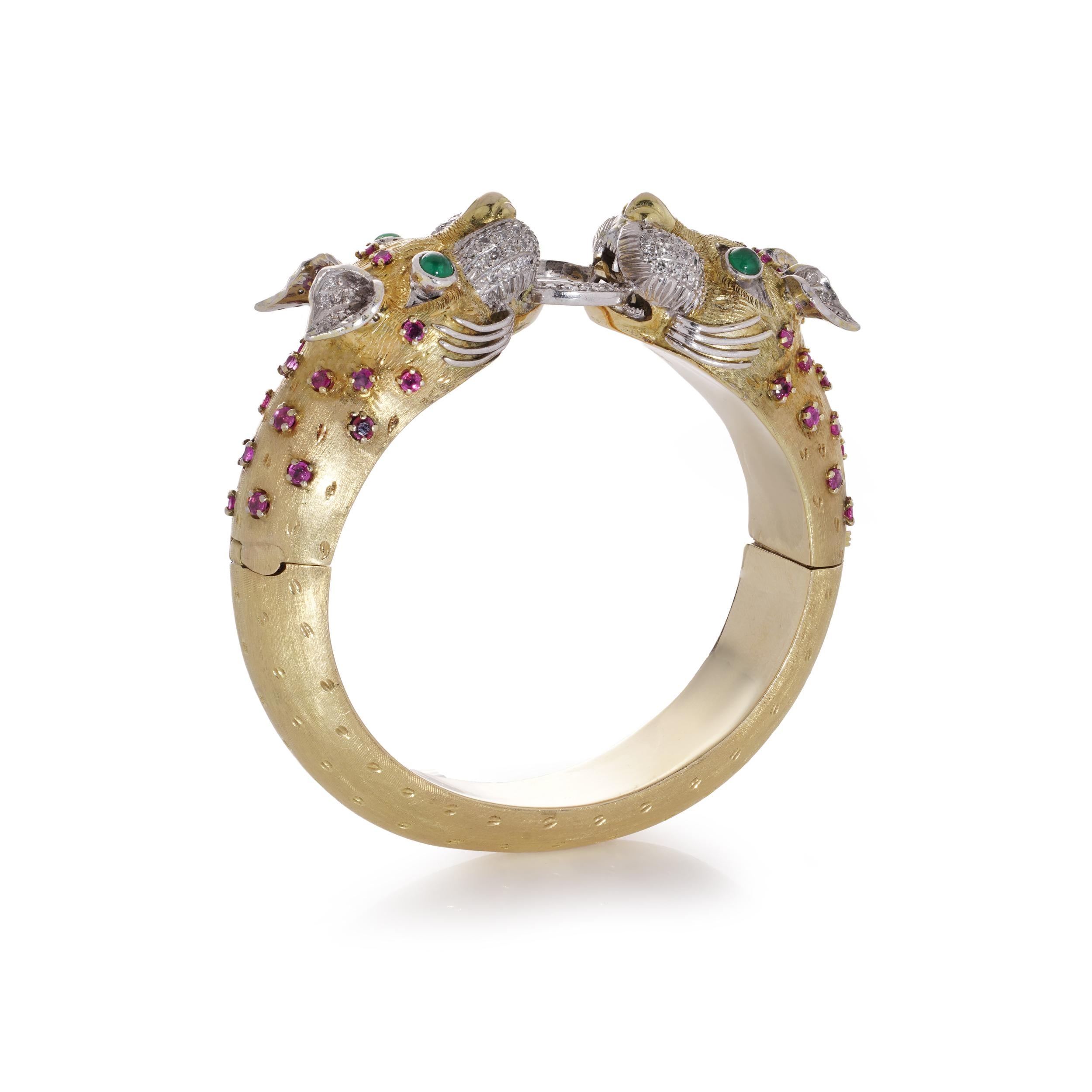 Larry yellow and white gold bangle with two dragon heads with 118 diamonds, emeralds, and rubies.

Approx. Dimensions:
The bangle has an inner diameter: of 59.7 mm x 53.6 mm ( longest x shortest).
The top width is 22.6 mm
The width at the bottom was