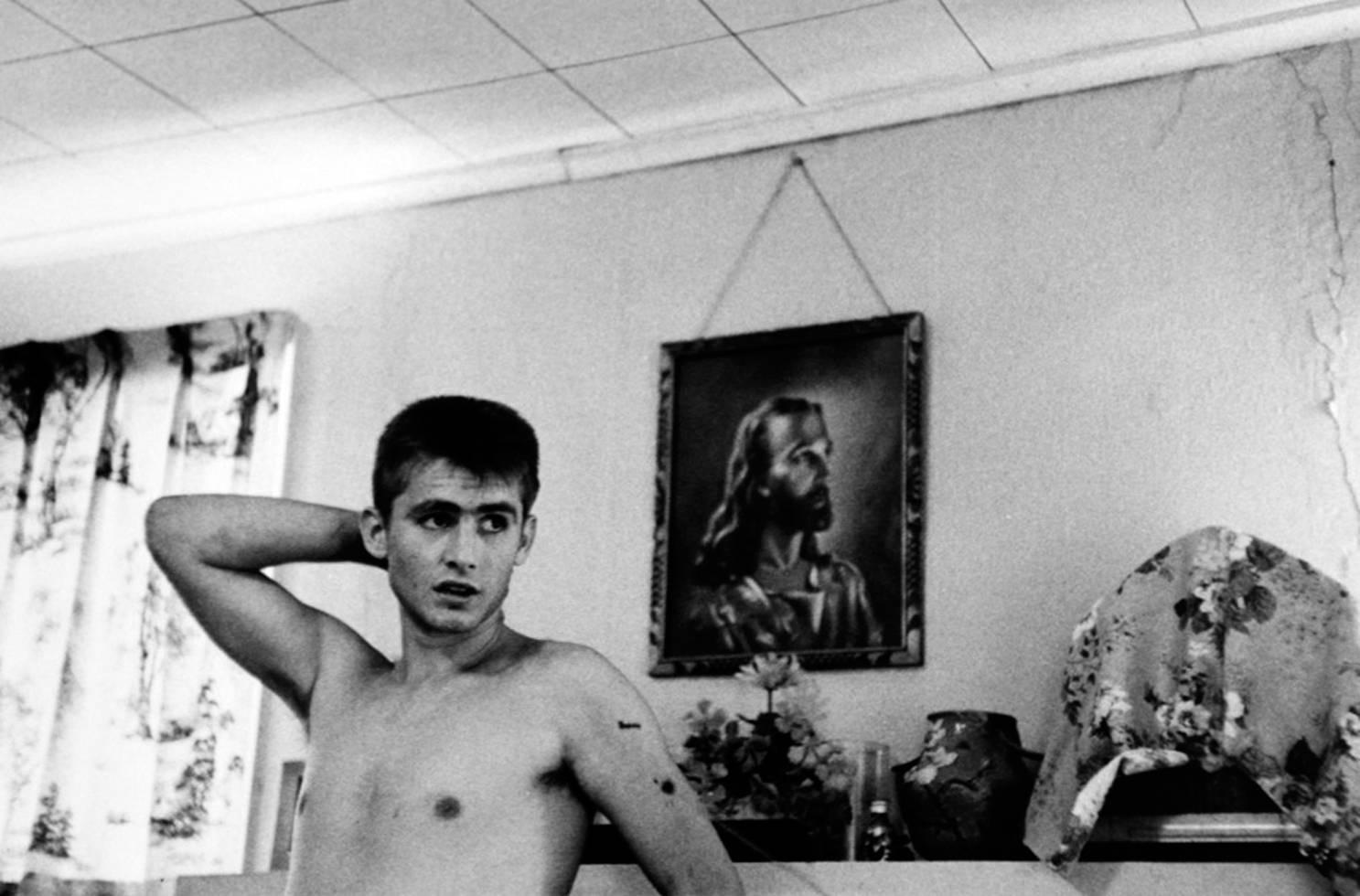 Larry Clark Black and White Photograph - Untitled (David in Front of Mantle, from the series "Tulsa")