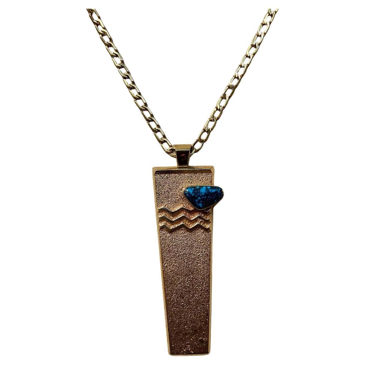 Questa splendida collana e questo ciondolo in turchese e oro giallo a 14 carati sono stati realizzati a mano da un'artista della gioielleria che in passato ha studiato architettura. Larry Golsh, della Missione Pala e dei popoli Cherokee, è uno degli